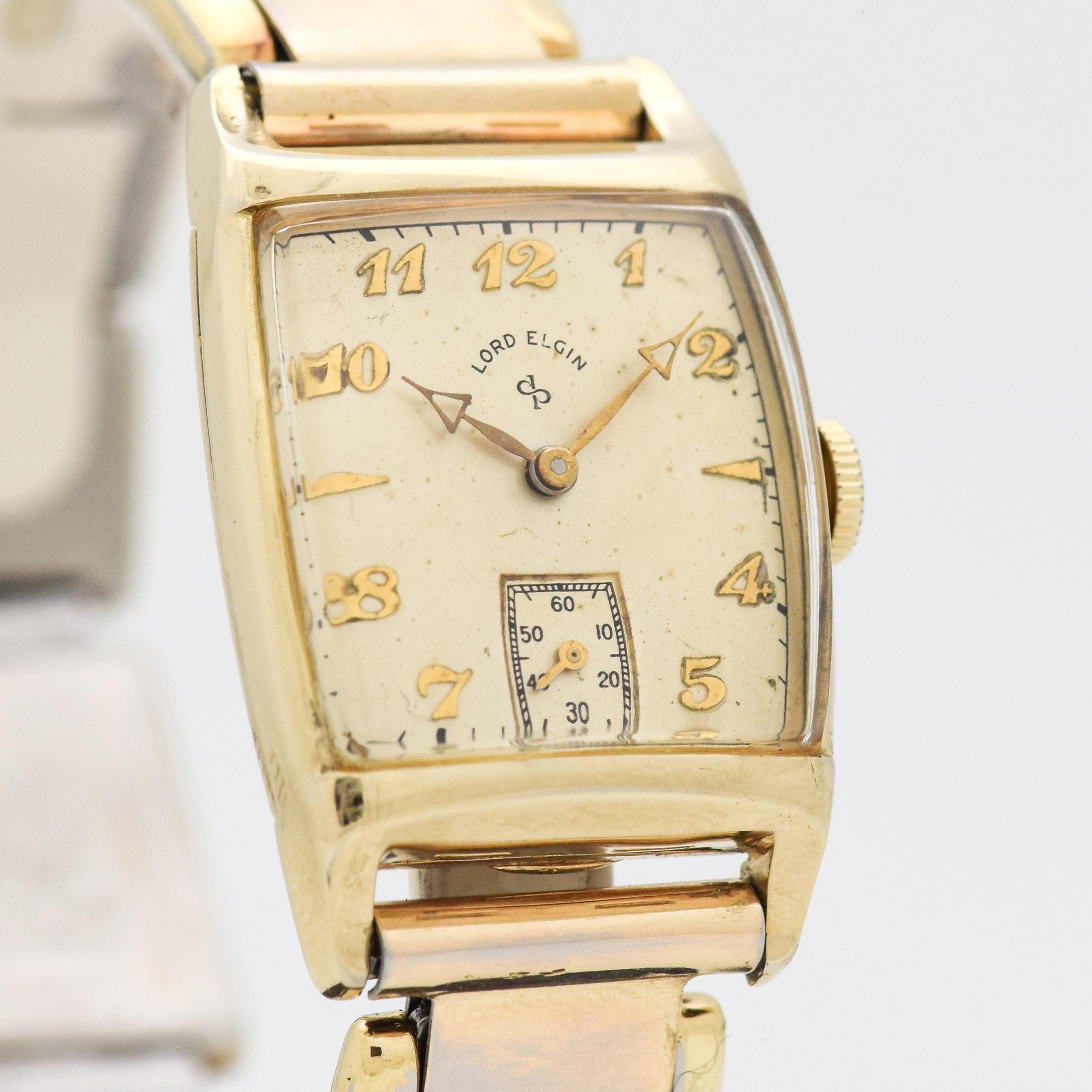 1949 Vintage Lord Elgin 14k Yellow Gold Filed watch with Original Silver Dial with Applied Breguet Arabic Gold Color Numbers and Elongated Triangles with Time Period Correct 14k Yellow Gold Filled Stretchy Bracelet. 24mm x 37mm lug to lug (0.94 in.