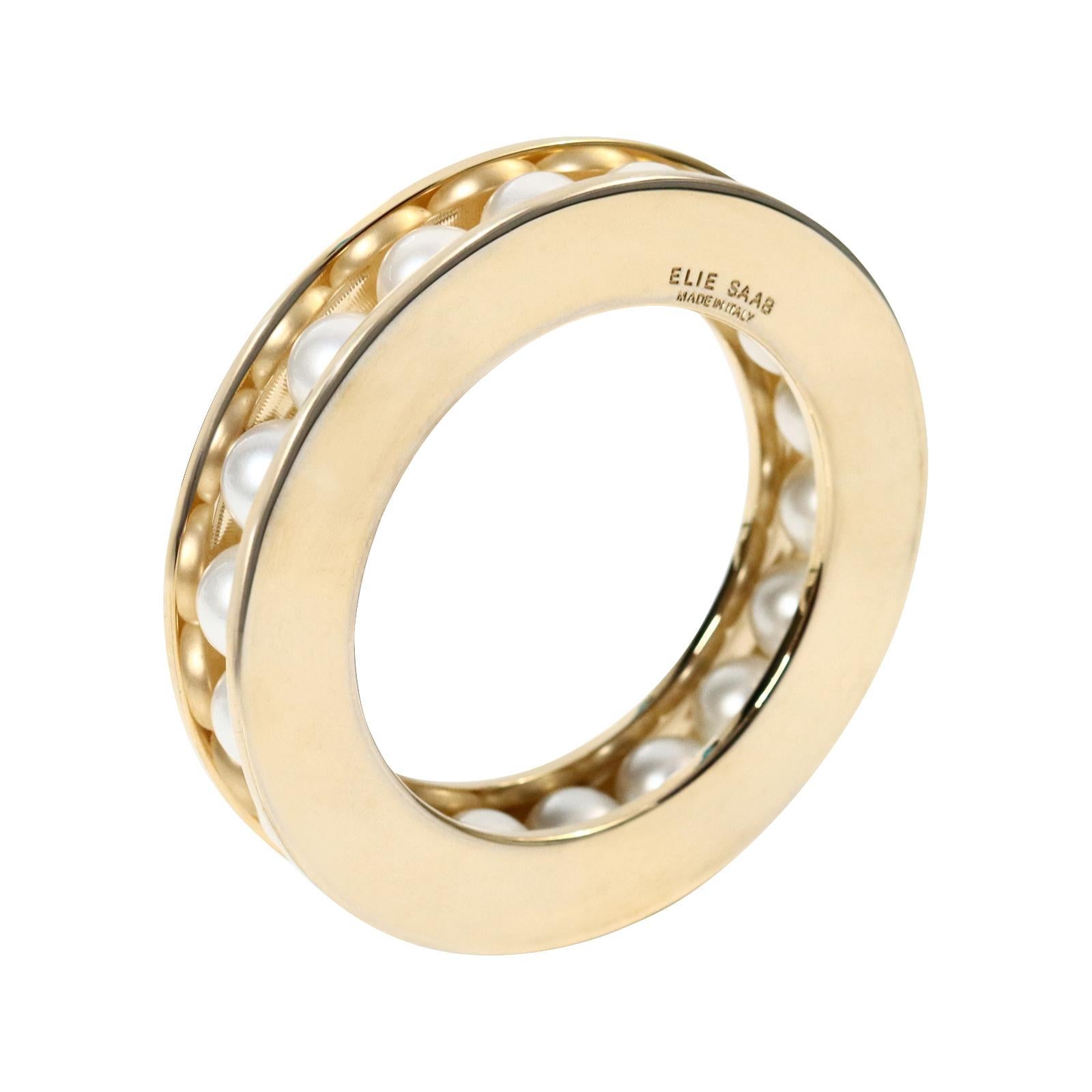 Vintage Elie Saab Gold Tone With Faux Pearls Bracelet Circa 2000s. This bracelet features channel-set, hidden faux pearls set with two pieces of gold-toned, shiny metal on top and bottom, creating a heavy and substantial design that is truly