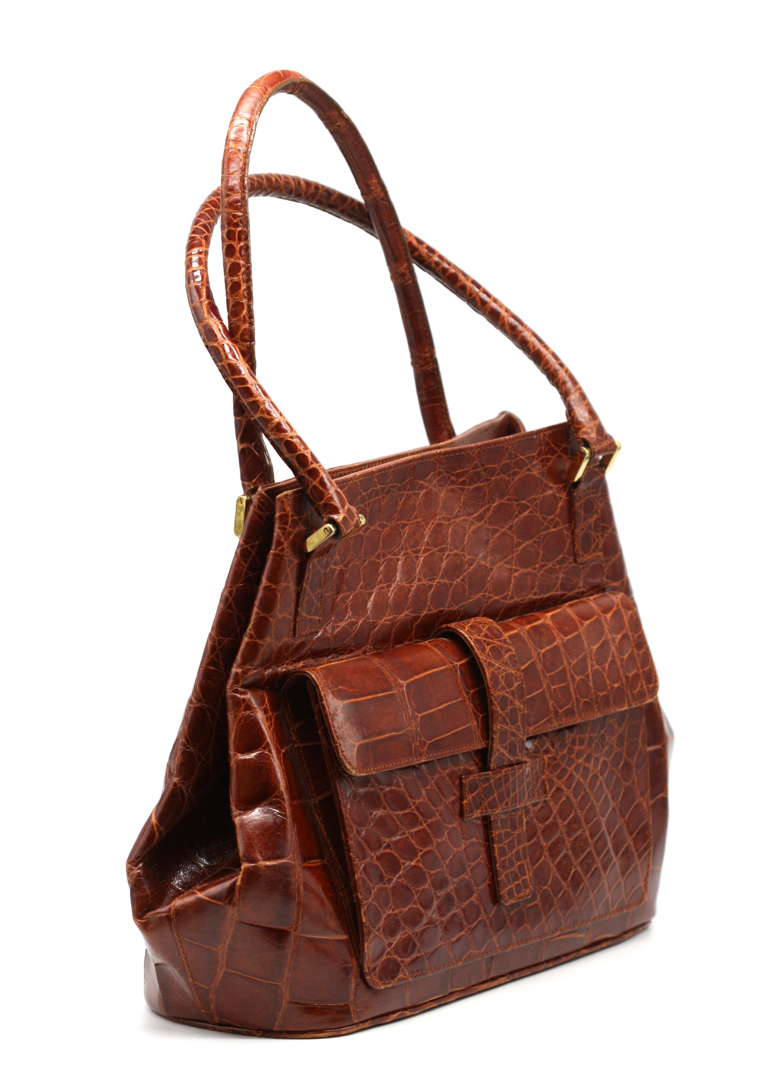 
Vintage Elizabeth Brown Alligator Handbag
Italian, with exterior flap pocket with strap closure, double stitched rolled handles, gold-toned hardware, the brown leather lined interior with a zippered pocket and two additional slit pockets.
Height,