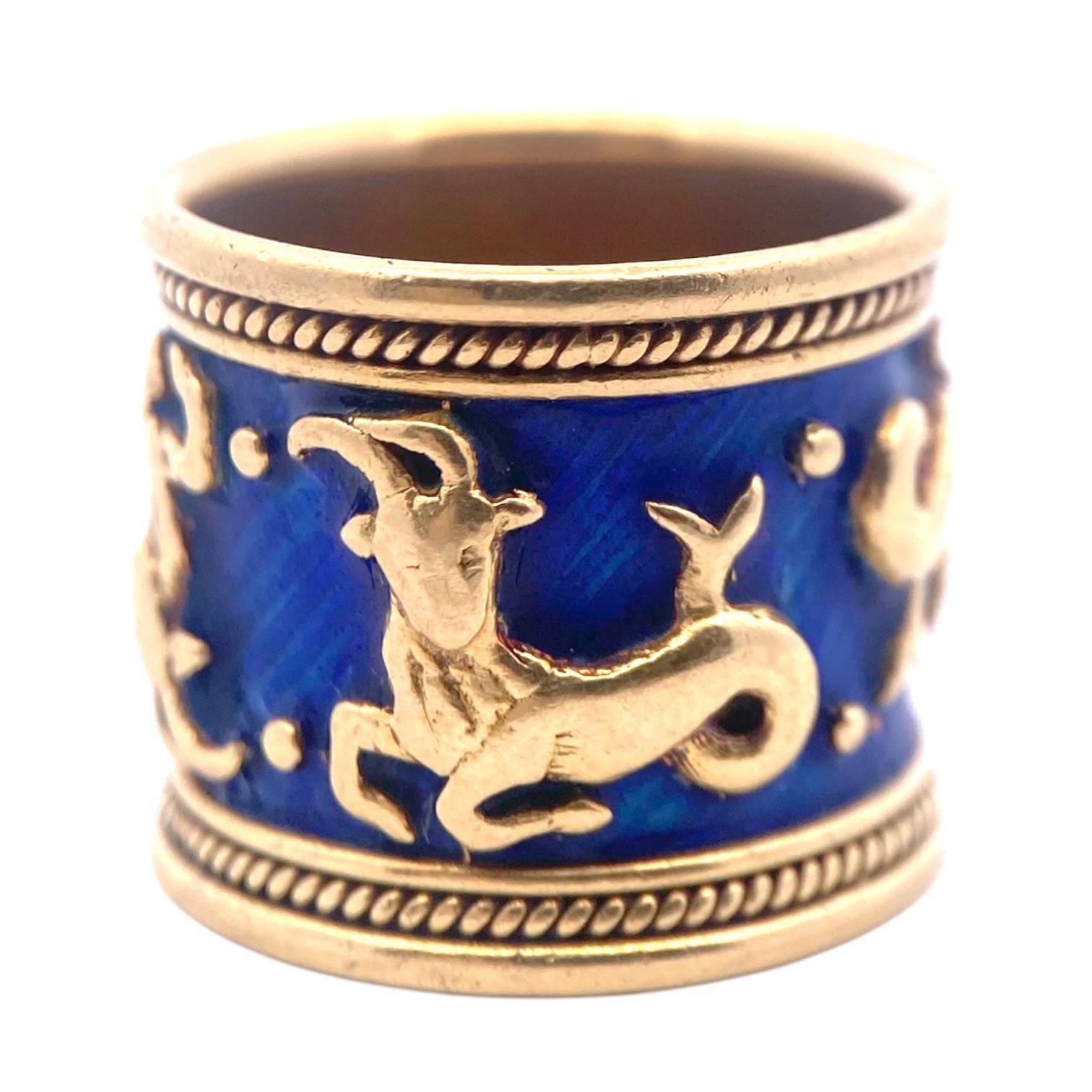 Vintage Elizabeth Gage 18K gold band from the Zodiac Collection. The ring features the Capricorn sign with cobalt blue enamel providing contrast to the warm yellow gold, highlighting the design's elegance. The ring's intricate detailing is further