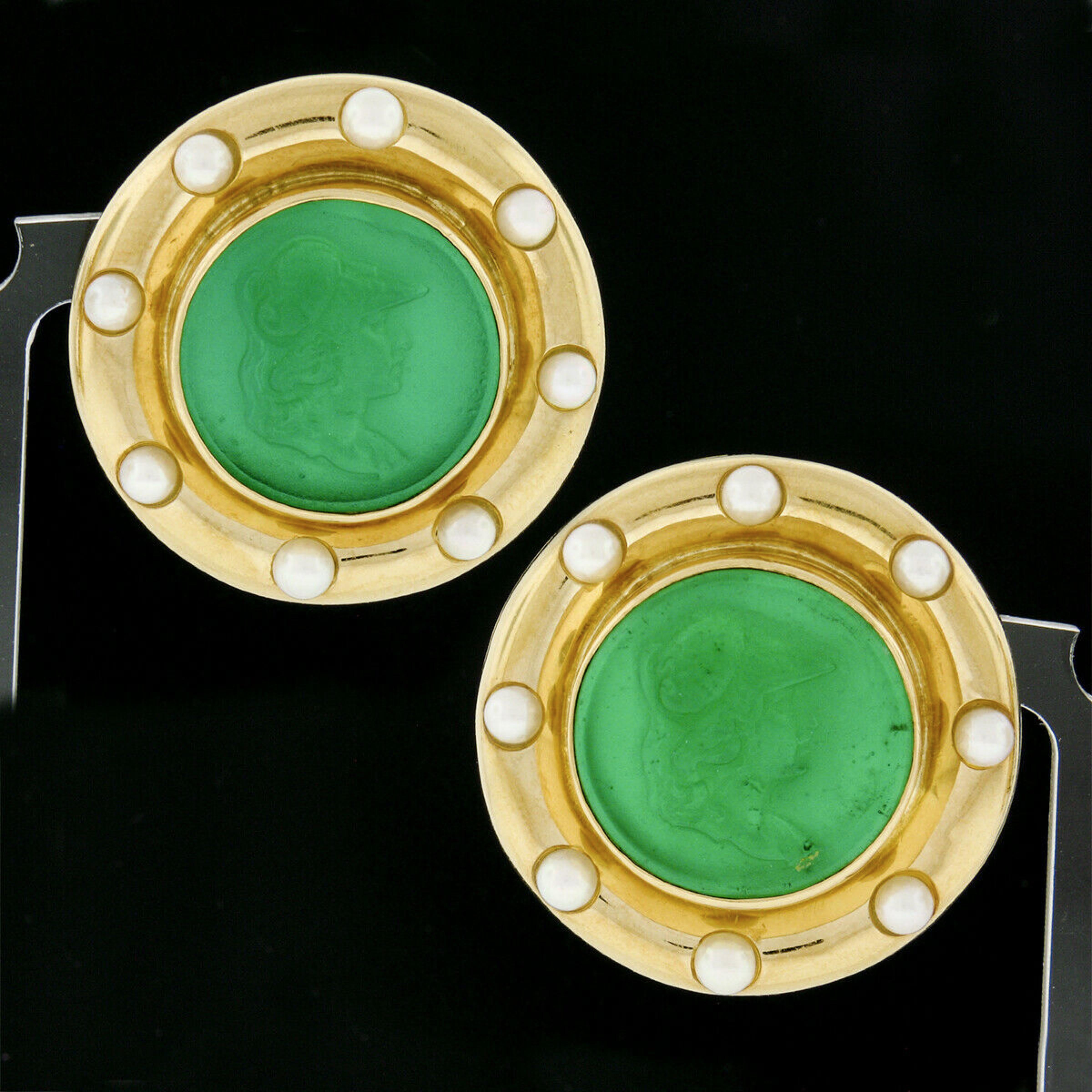 This unusual and truly stunning pair of vintage earrings by Elizabeth Locke are crafted in solid 18k yellow gold and each features a green glass intaglio that is bezel set above a white mother of pearl disk in the background. The detailed intaglio