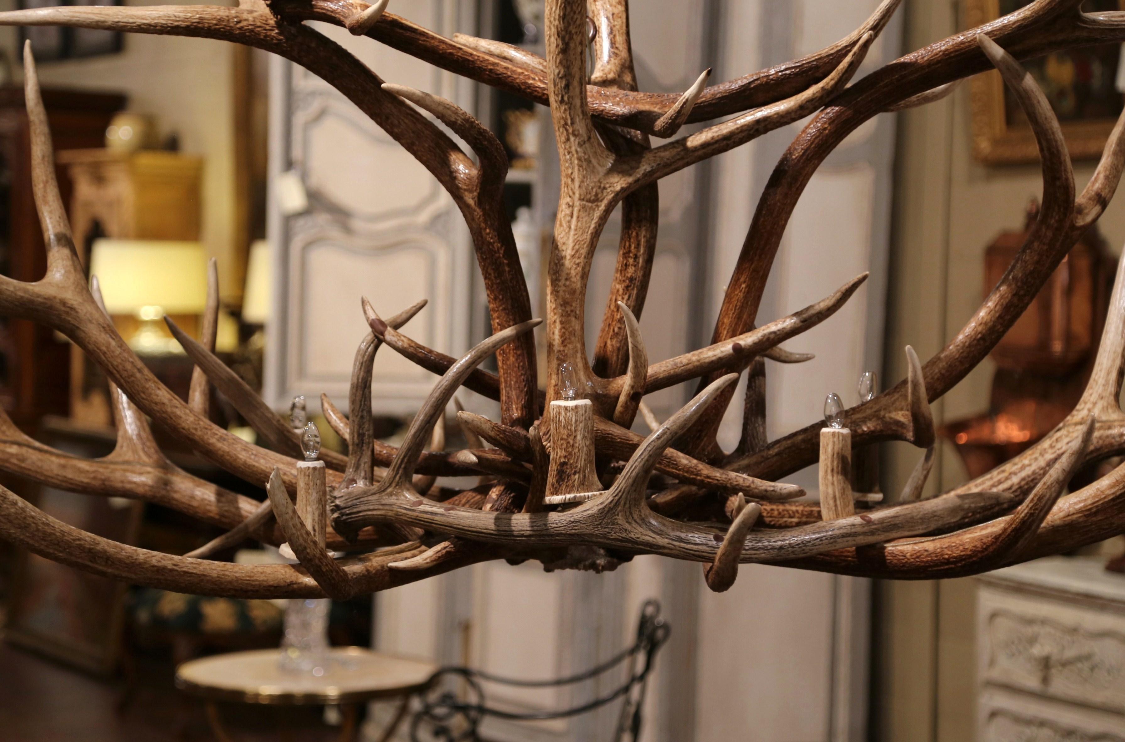 Decorate a ranch or a log cabin with this monumental real antler chandelier! Handcrafted in North America and over 6 foot wide, the large fixture is built using a dozen natural elk, white tail and mule horns; it has ten lights and is further