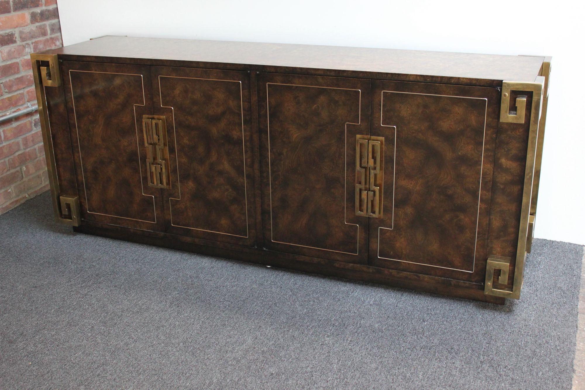 Luxurious plinth-base credenza / sideboard in burled Carpathian elm wood with inlaid brass details and highly stylized Greek Key brass hardware designed by William Doezema for Mastercraft Furniture distributed by Charak (circa 1970, USA).
The