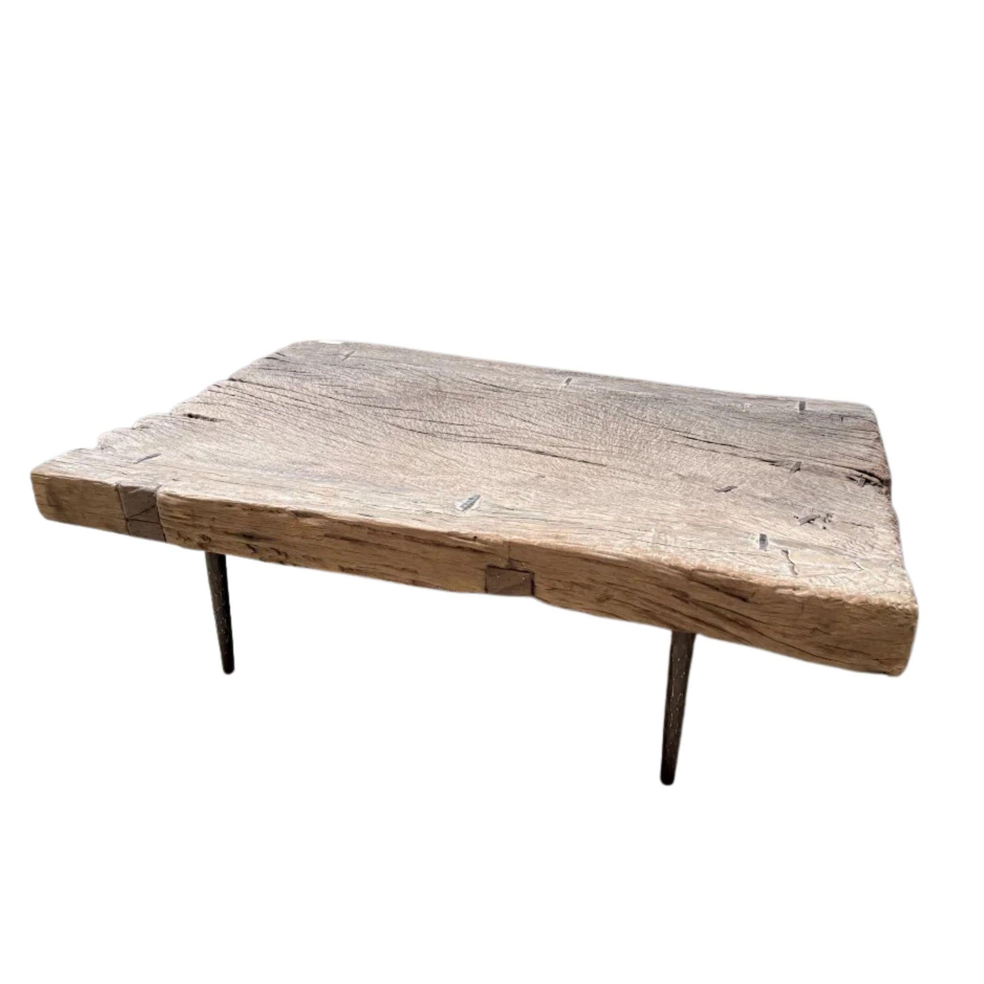 Sculptée à partir d'une seule plaque d'orme du début du XXe siècle et de deux planches jointives,  cette table basse incarne l'imperfection tranquille et la profondeur tactile du design wabi-sabi. La surface usée par le temps, adoucie par des