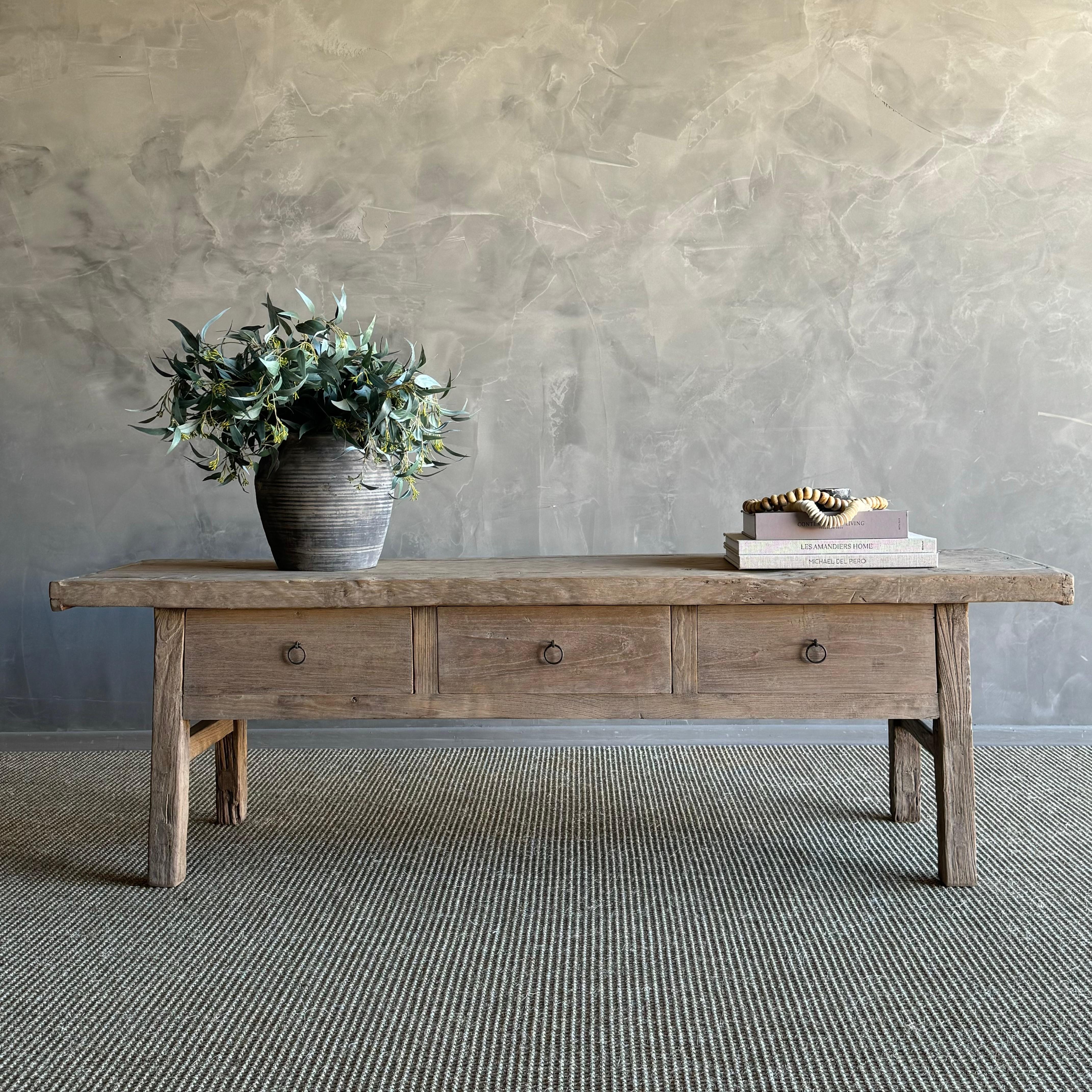 Introducing the authentic Vintage Elm Coffee Table with Drawers, a rare find for those who appreciate the beauty of natural wood. Each piece features stunning grain patterns and unique fissures that make it a one-of-a-kind addition to your space.