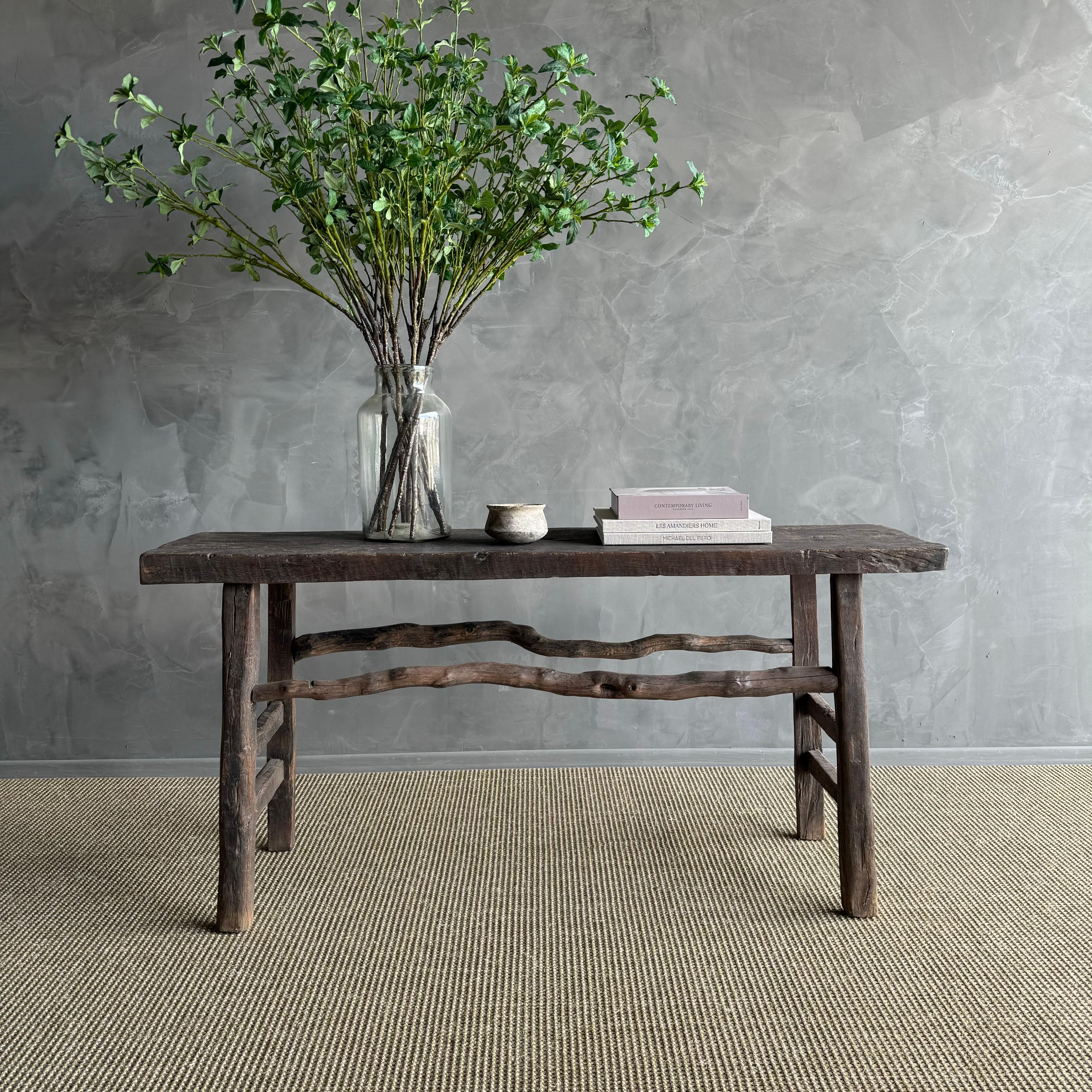 Introducing a stunning vintage elm wood console, a true one-of-a-kind piece exuding beautiful age and patina. Its weathered finish adds character and charm to any space. Crafted from solid elm wood with rustic branch stretchers, this unique console