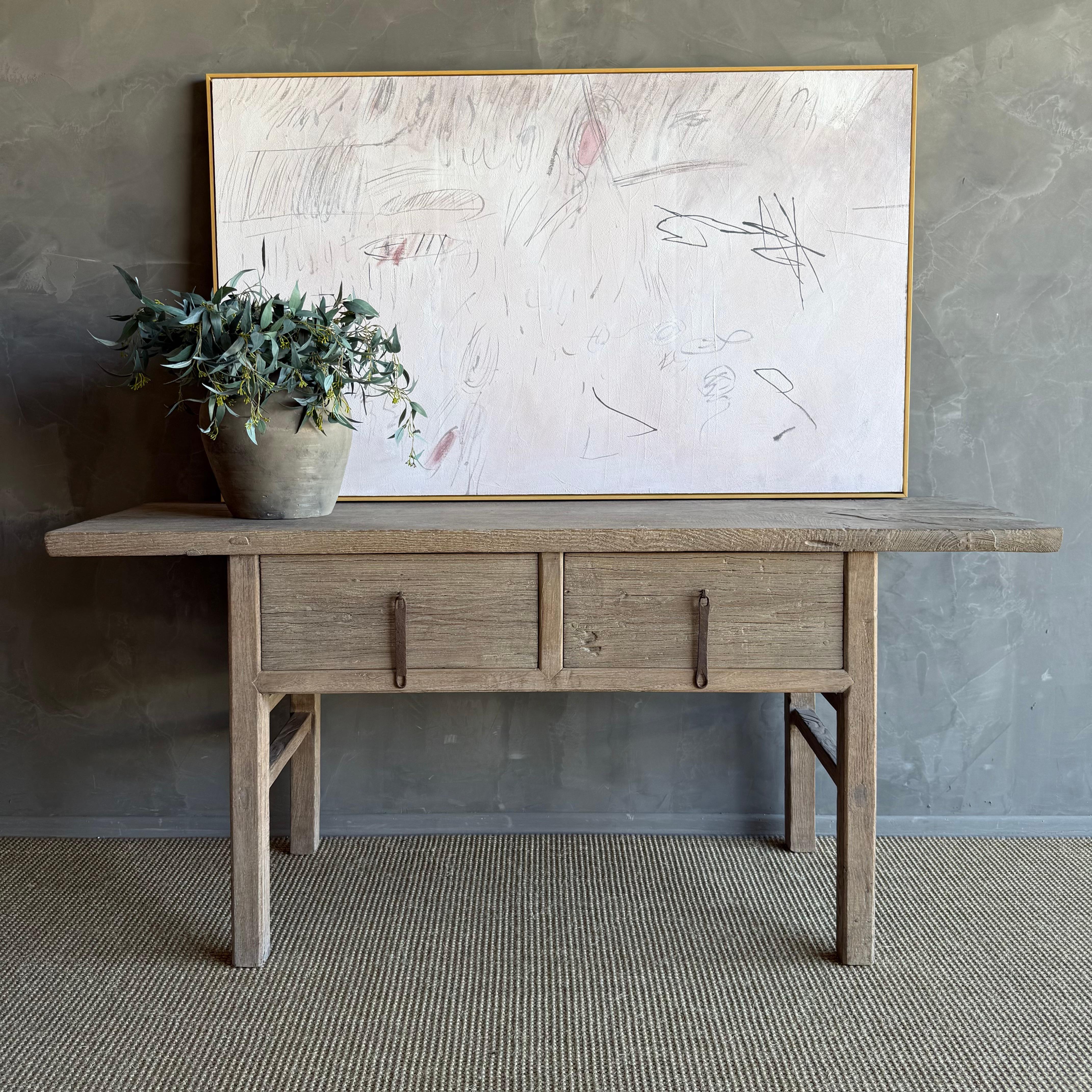 This charming vintage elm wood console is a one-of-a-kind piece with beautiful age and patina that adds character to any space. Its patina painted elm wood finish showcases the natural beauty of the wood, while the solid elm wood original hardware