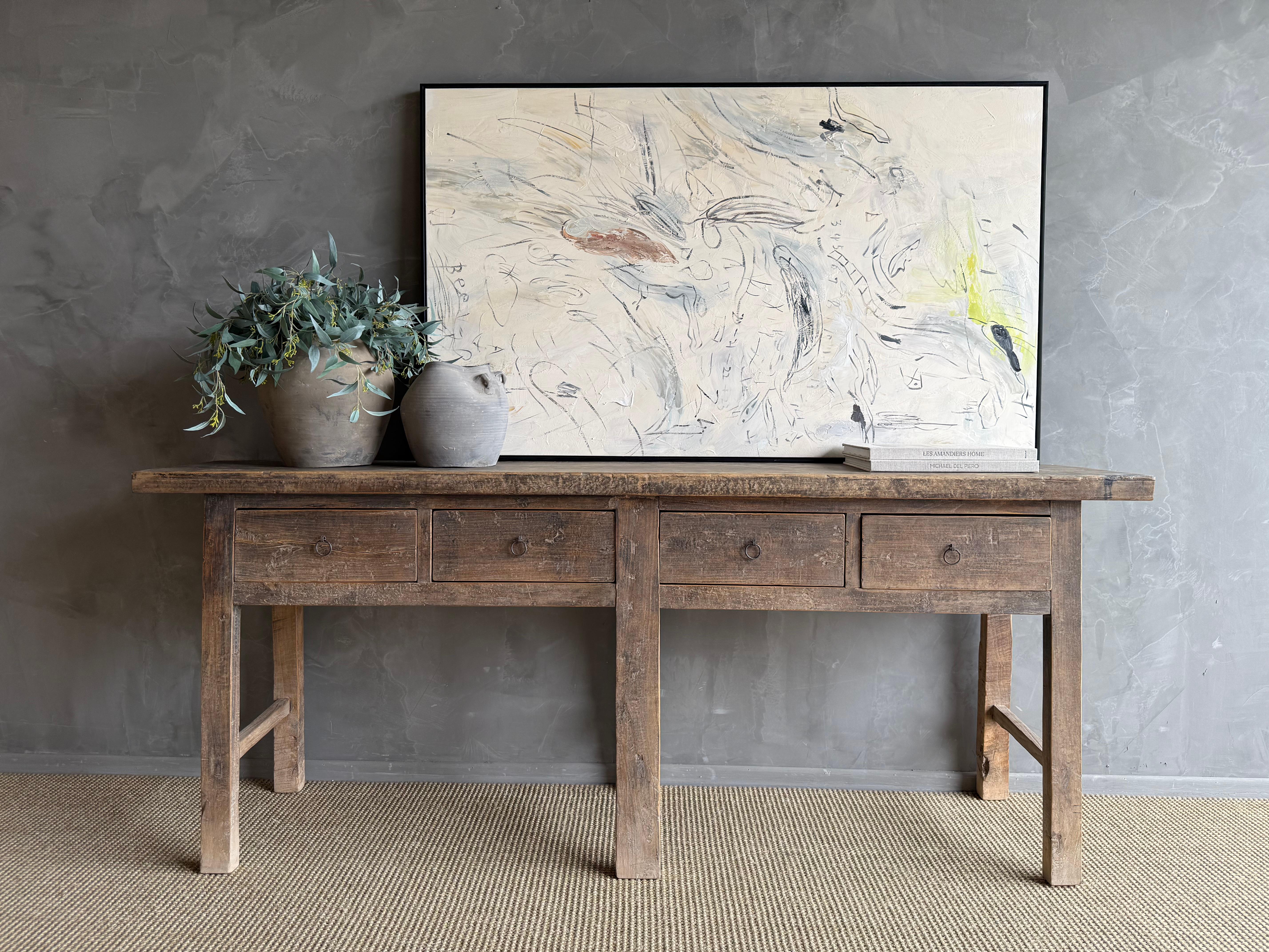 Cette charmante console vintage en bois d'orme est une pièce unique avec une belle patine d'âge qui ajoute du caractère à n'importe quel espace. Sa finition en orme peint patiné met en valeur la beauté naturelle du bois, tandis que la quincaillerie
