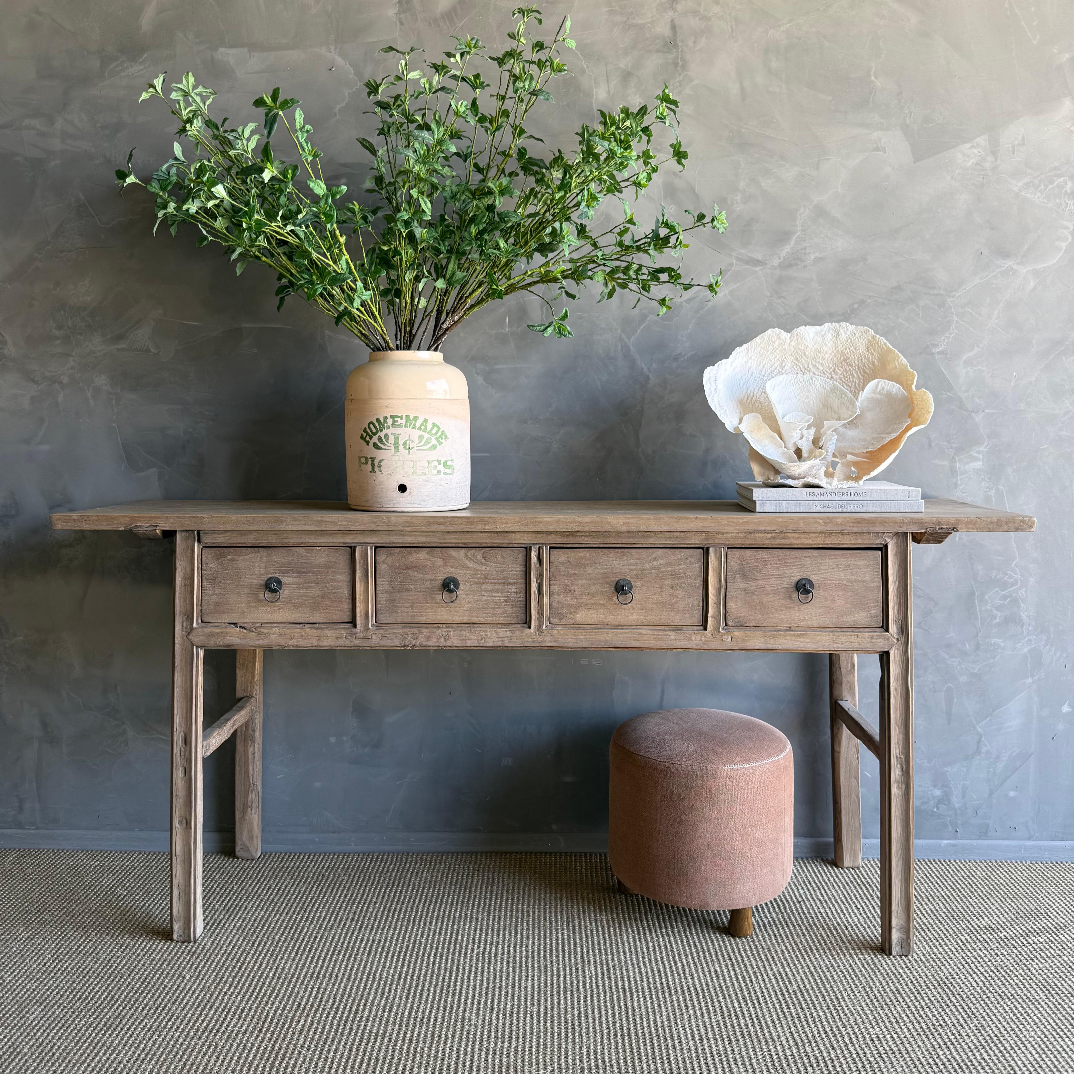 Cette charmante console vintage en bois d'orme est une pièce unique avec une belle patine d'âge qui ajoute du caractère à n'importe quel espace. Sa finition en orme peint patiné met en valeur la beauté naturelle du bois, tandis que la quincaillerie