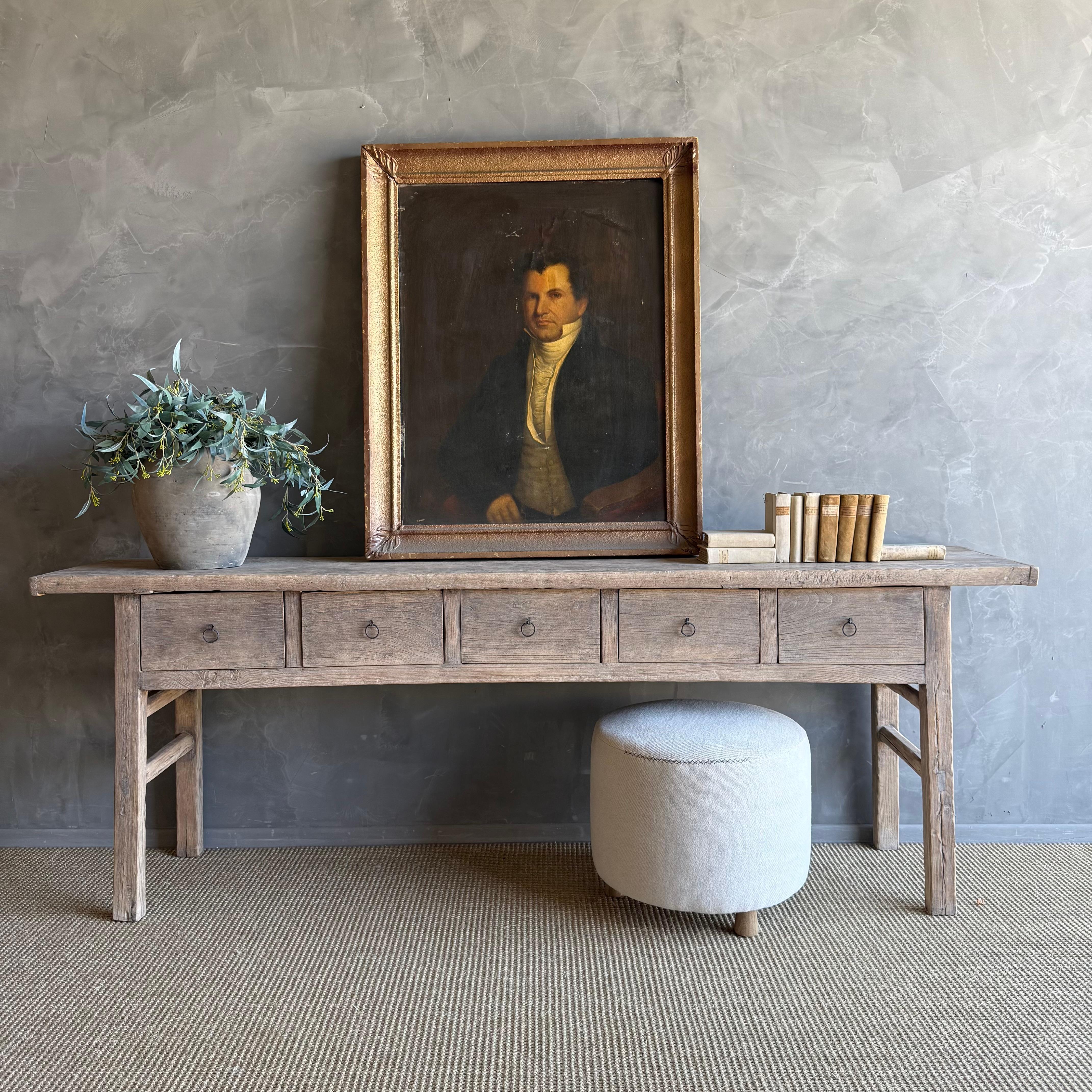 Cette charmante console vintage en bois d'orme est une pièce unique avec une belle patine d'âge qui ajoute du caractère à n'importe quel espace. Sa finition en orme peint patiné met en valeur la beauté naturelle du bois, tandis que la quincaillerie