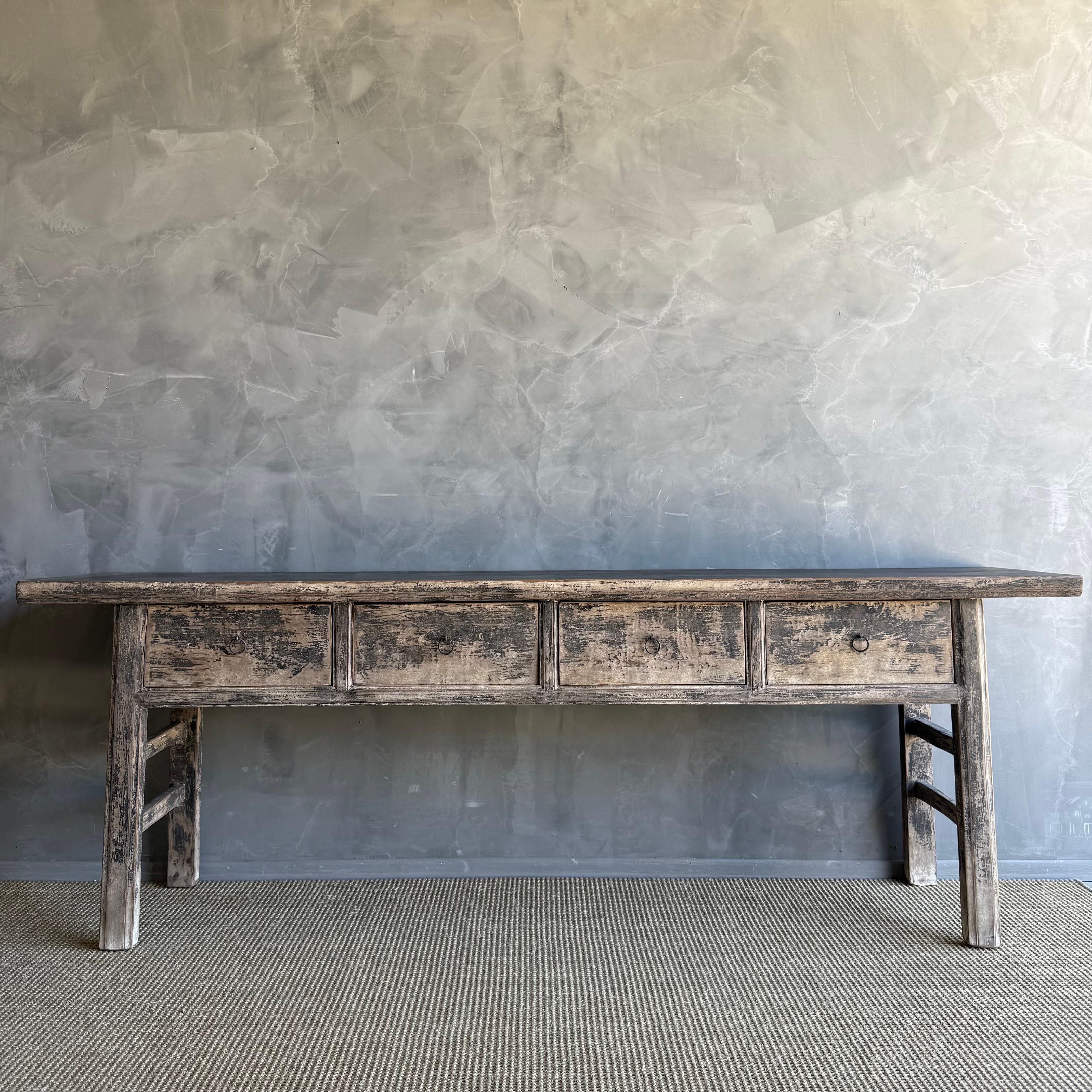This charming vintage elm wood console is a one-of-a-kind piece with beautiful age and patina that adds character to any space. Its patina painted elm wood finish showcases the natural beauty of the wood, while the solid elm wood original hardware