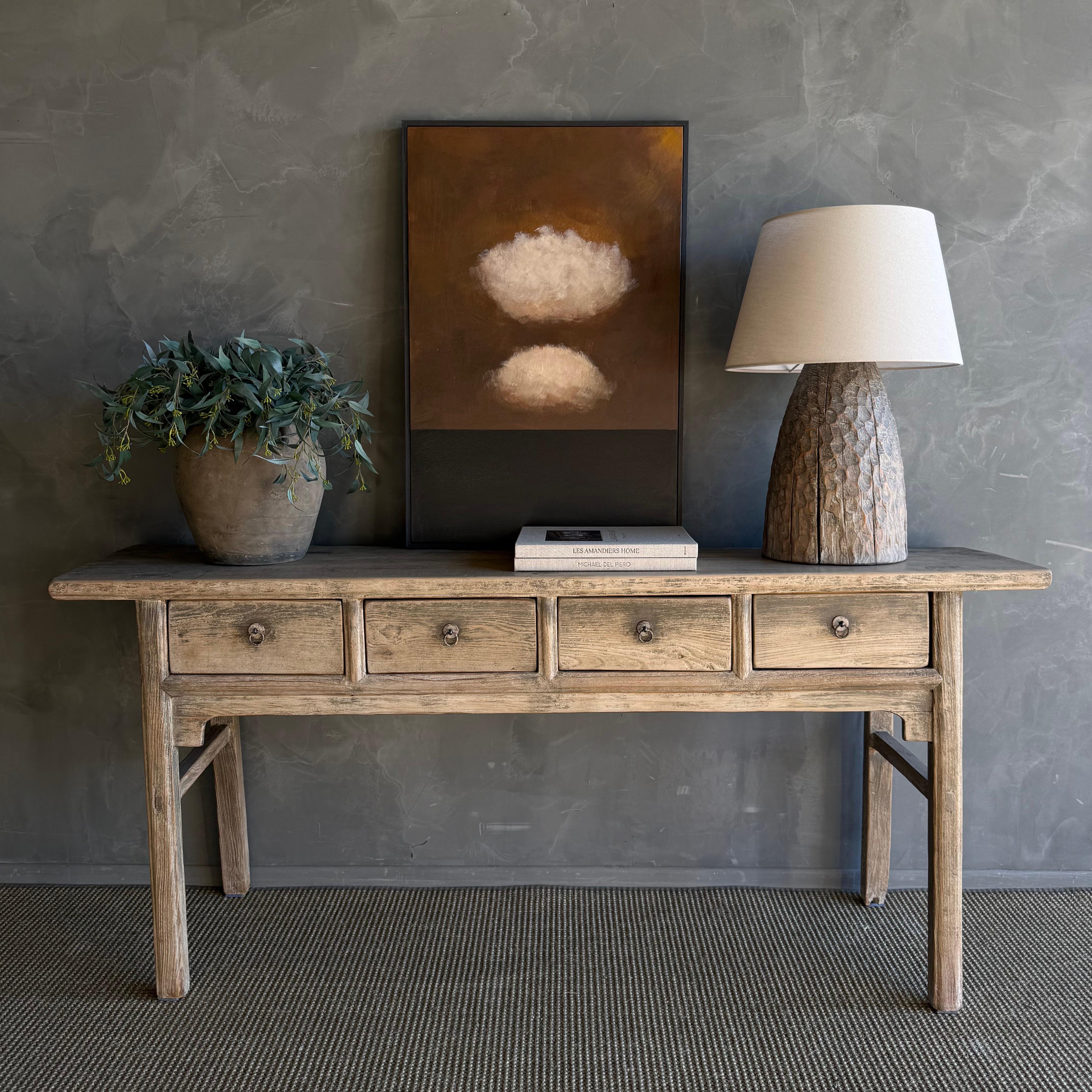 This charming vintage elm wood console is a one-of-a-kind piece with beautiful age and patina that adds character to any space. Its patina painted elm wood finish showcases the natural beauty of the wood, while the solid elm wood original hardware