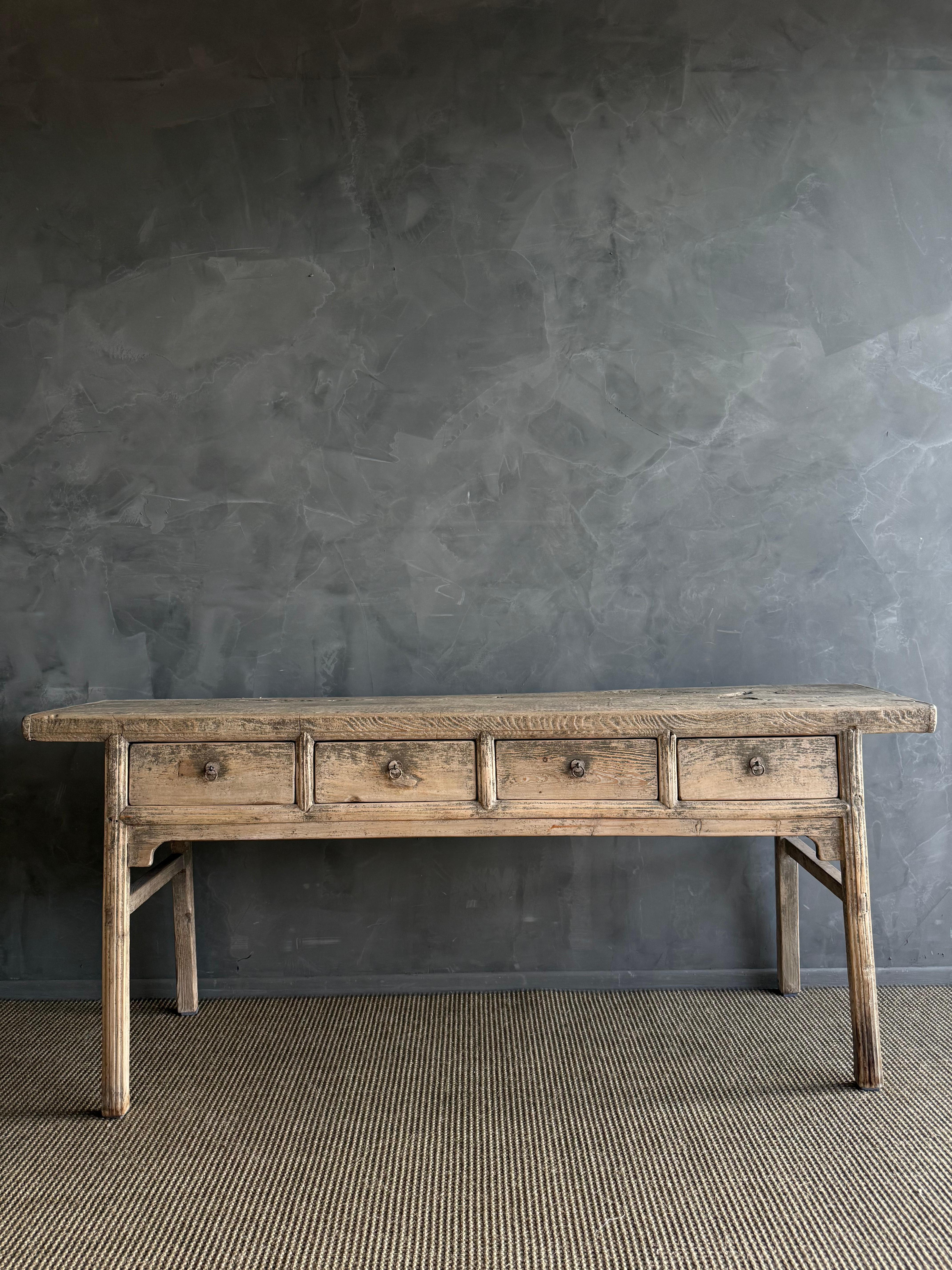 This charming vintage elm wood console is a one-of-a-kind piece with beautiful age and patina that adds character to any space. Its patina painted elm wood finish showcases the natural beauty of the wood, while the solid elm wood original hardware