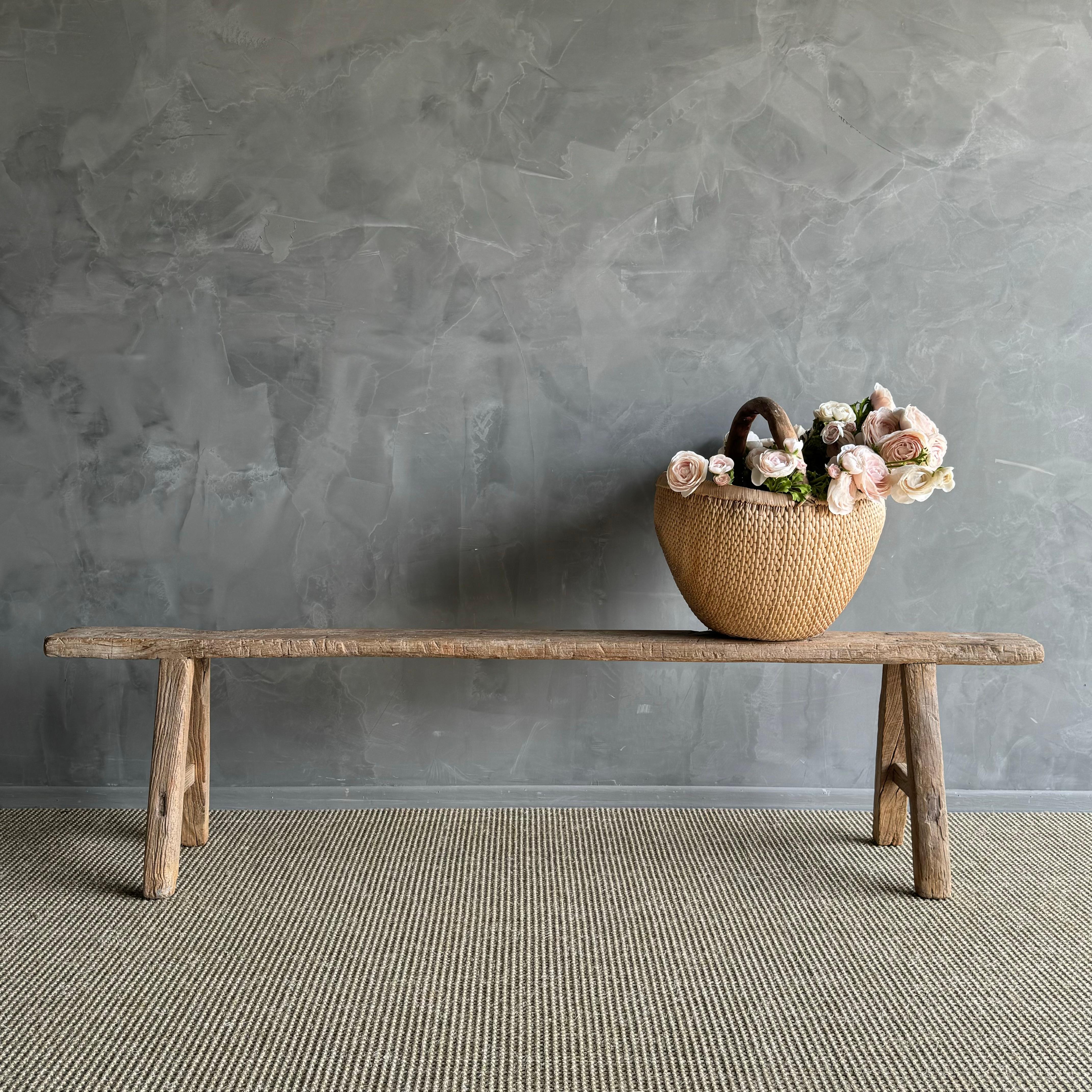 une trouvaille rare - le banc long et mince en bois d'orme vintage. Cet authentique banc vintage en orme est un véritable bijou, avec une longueur extra longue difficile à trouver qui le fait ressortir. La beauté du grain et des fissures ajoute du
