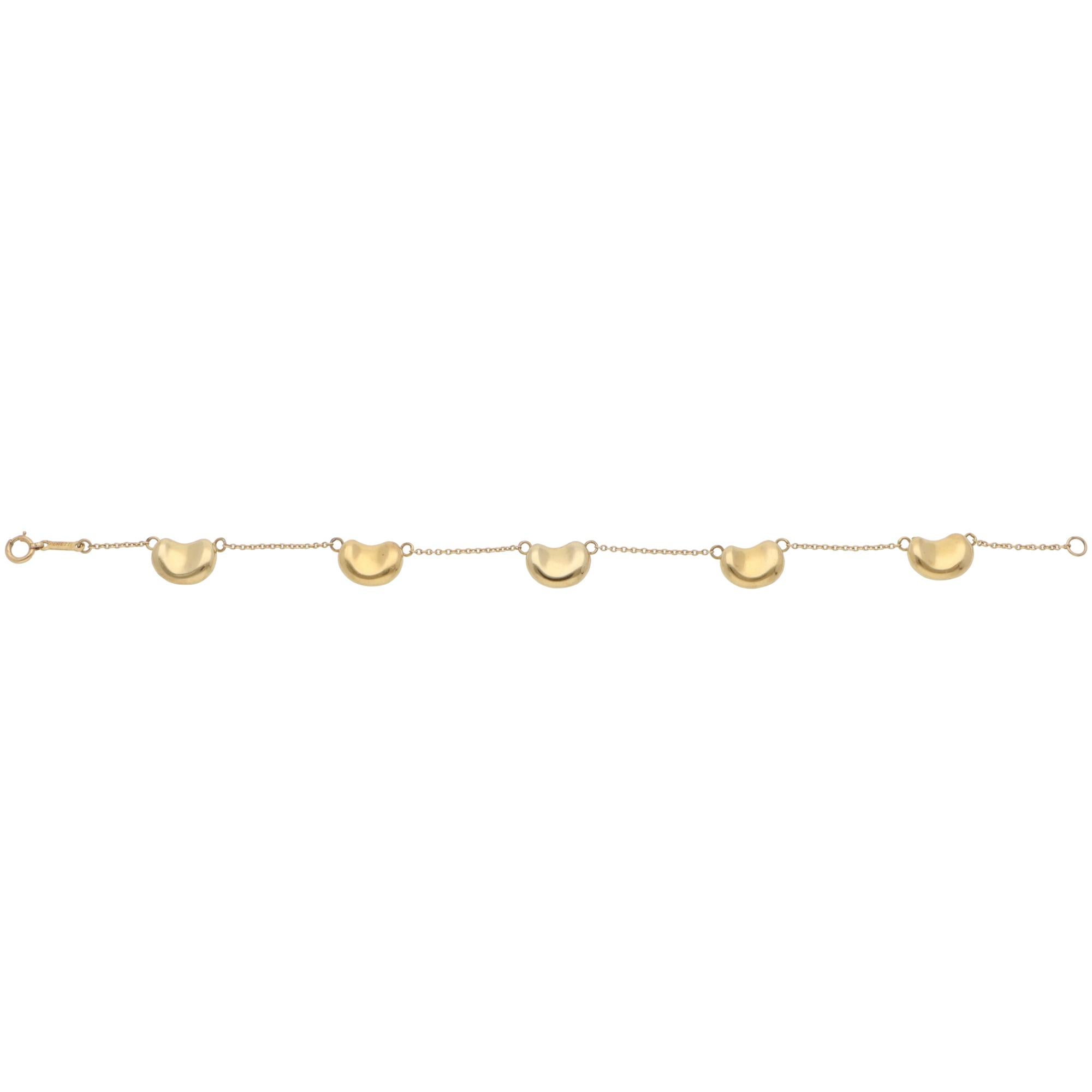 A beautiful vintage Elsa Peretti for Tiffany & Co. bean chain bracelet set in 18k yellow gold.

This piece features Elsa Peretti's iconic bean motifs, crafted from solid 18k yellow gold. The 5 beans are connected to each end with a single-stranded