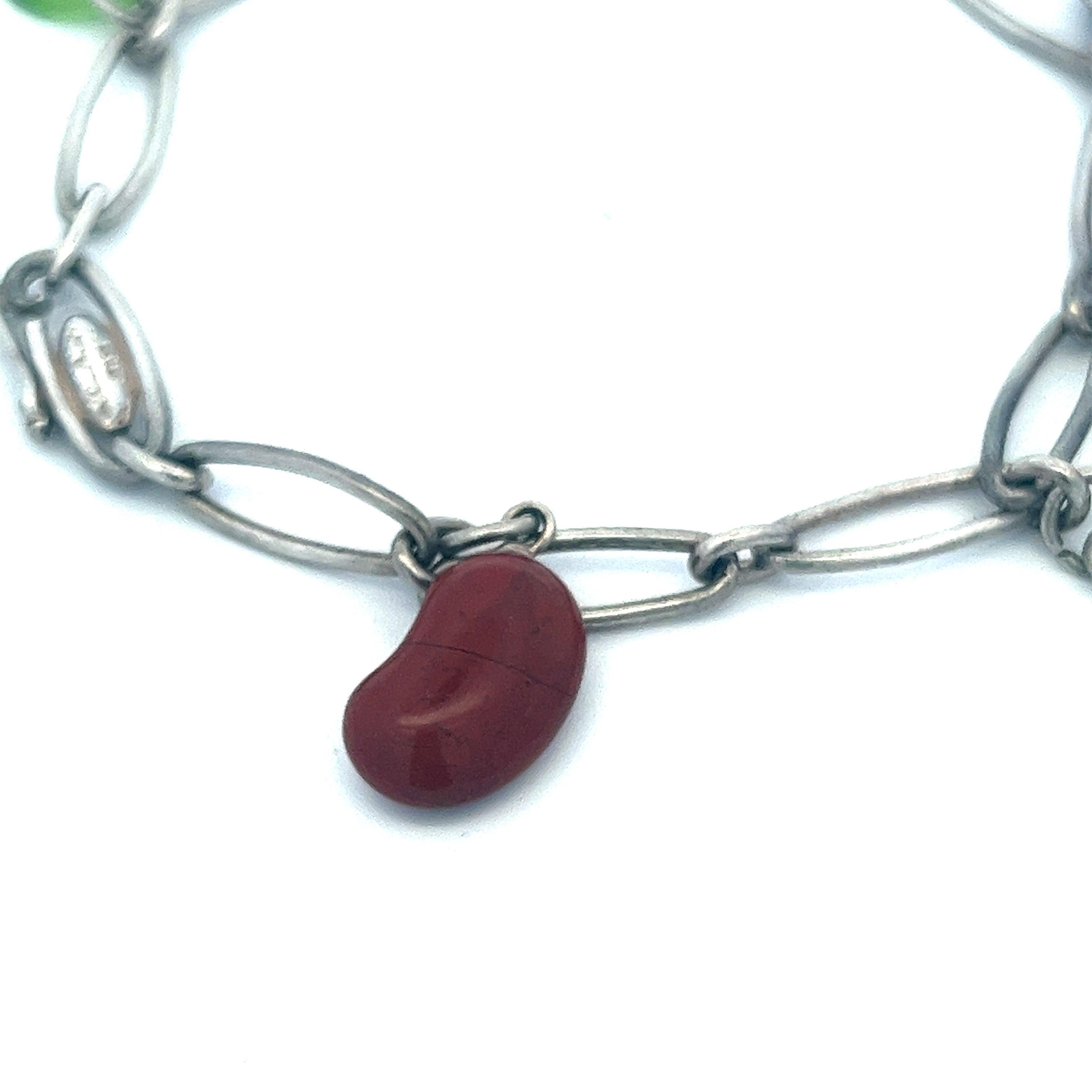 This iconic bracelet features five of Elsa Peretti's signature charms in one piece. It comprises a red jasper Bean®, a rock crystal Toy, a green jade Eternal Circle, a lapis lazuli disk, and a sterling silver apple. It is all held together by a