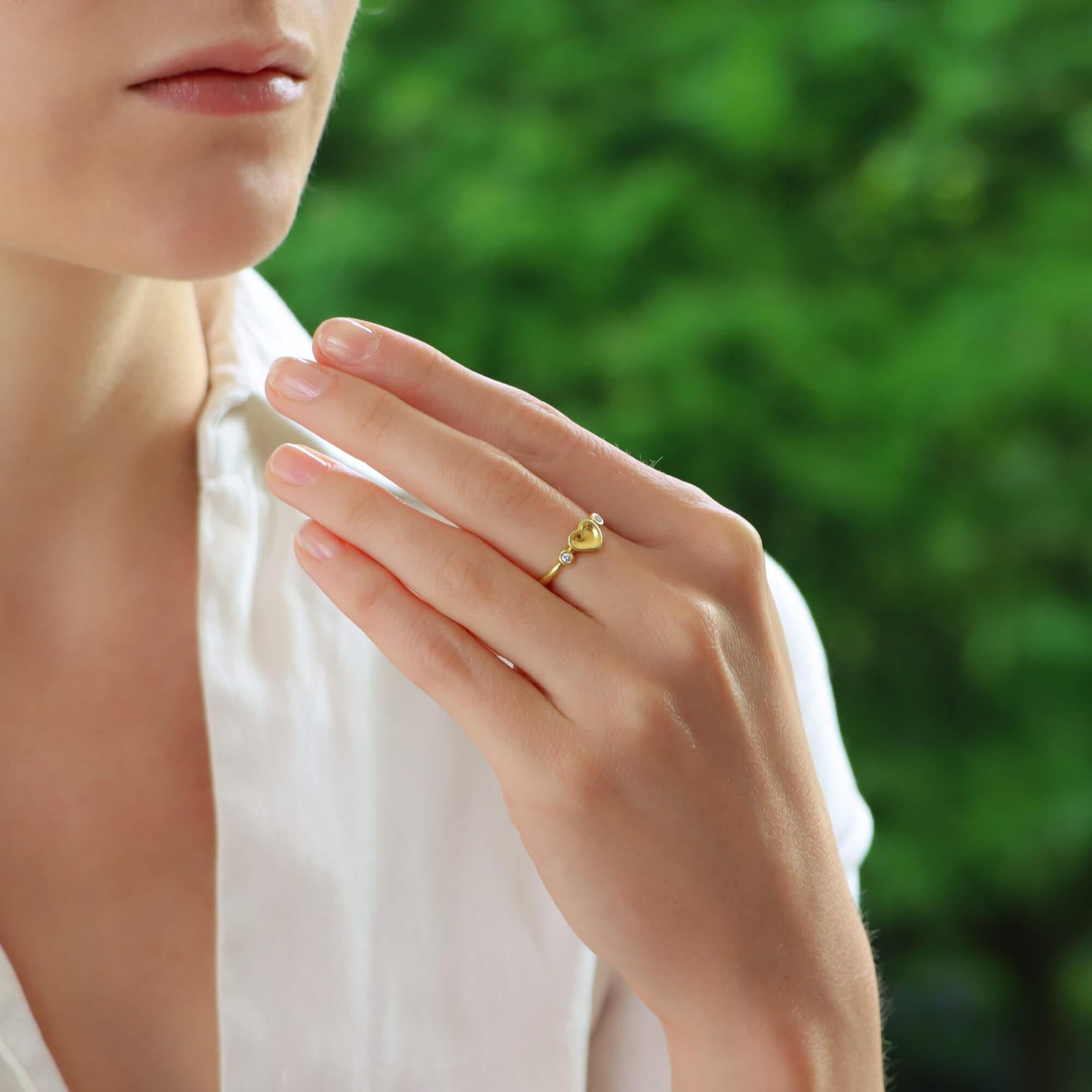  Magnifique bague vintage Elsa Peretti pour Tiffany & Co. en or jaune 18 carats, sertie d'un diamant en forme de cœur.

La bague représente le design emblématique du cœur plein d'Elsa Peretti et est flanquée de deux diamants ronds de taille