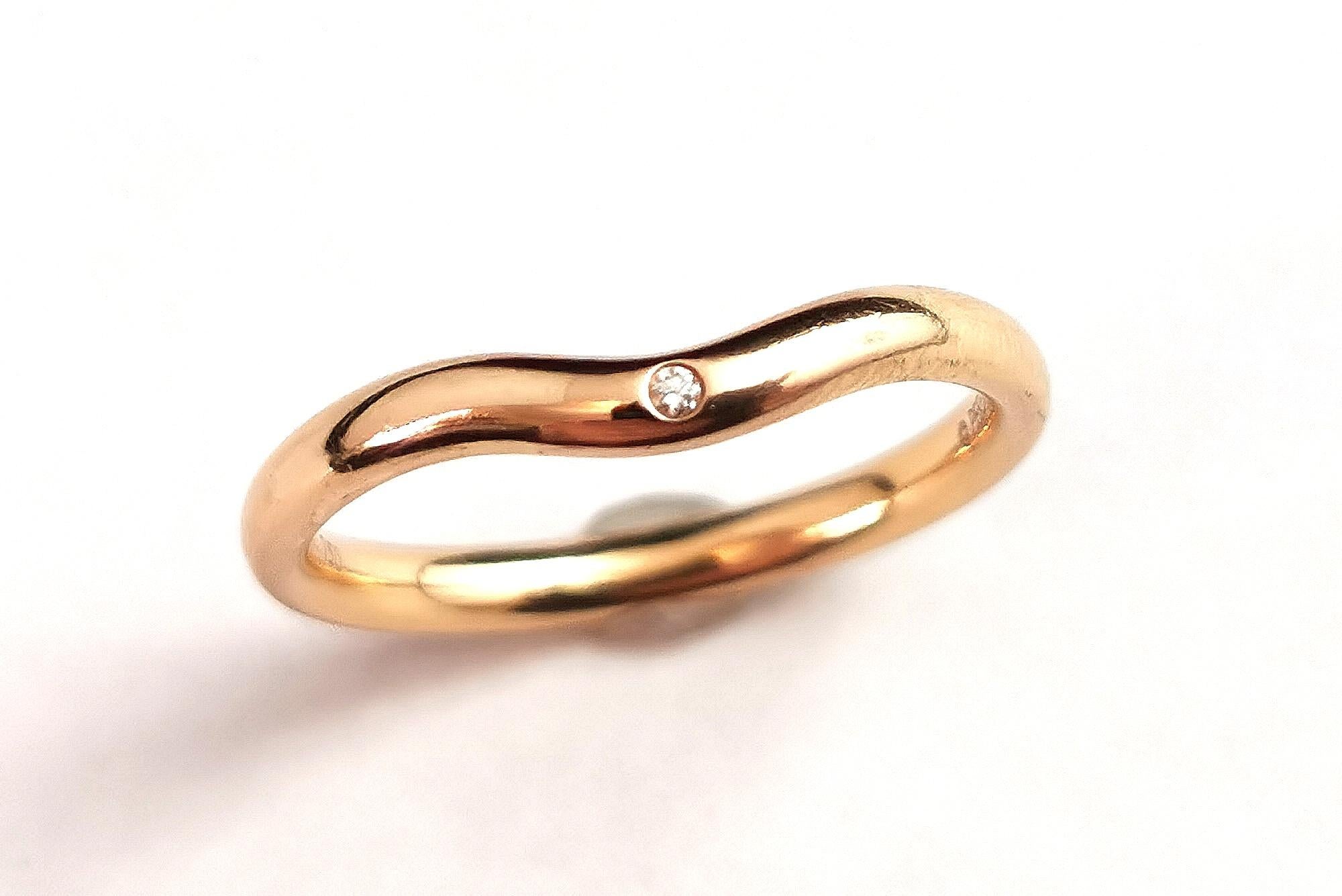 A beautiful vintage Elsa Peretti for Tiffany Classic 18kt yellow gold wedding band ring.

It has a smooth rich polished 18kt gold finish with a chevron or light wishbone shape to it.

The front is set with a single cut sparkling diamond.

A perfect