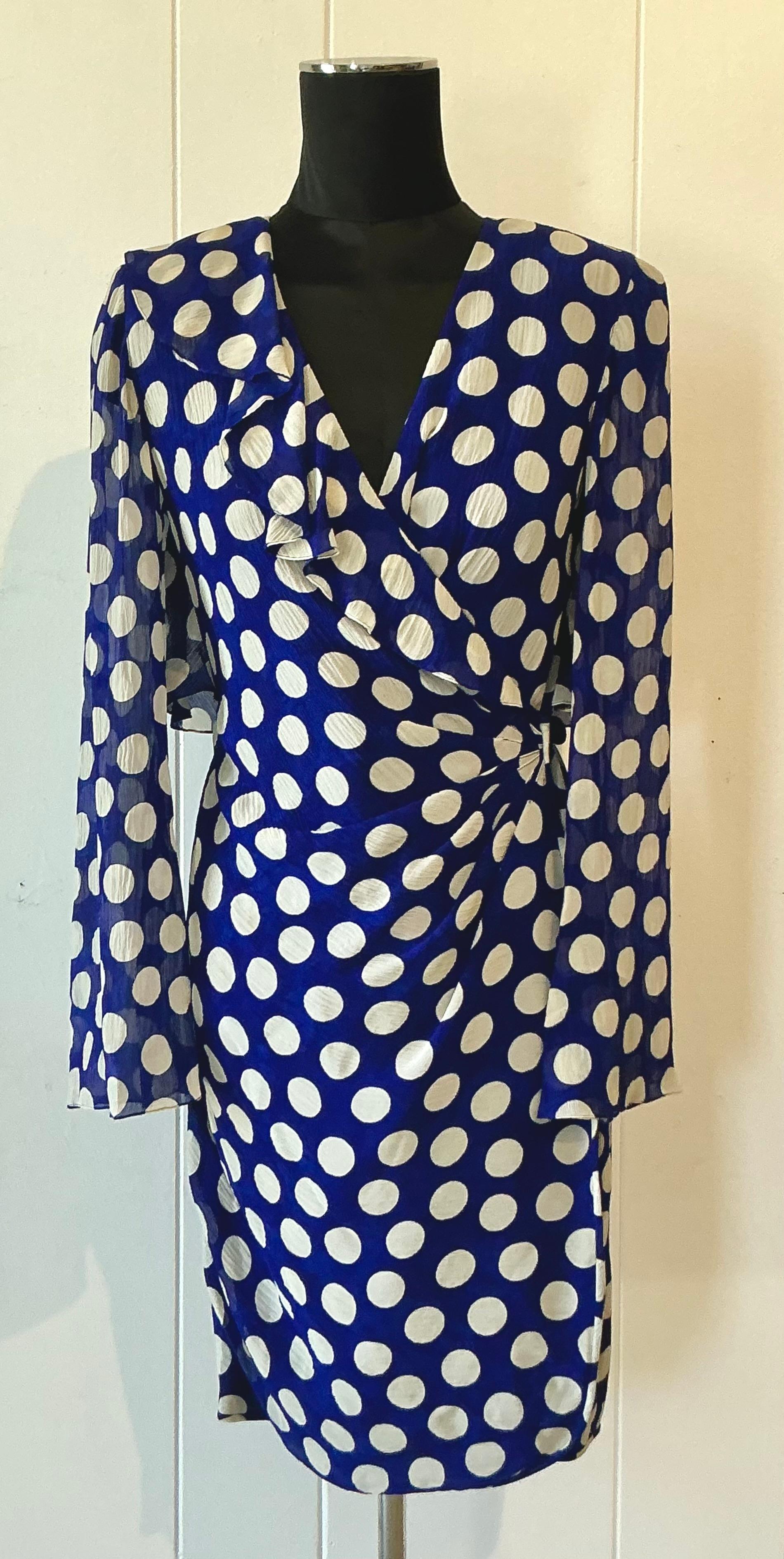 Dieses blau-weiß gepunktete Vintage-Kleid von Emanuel Ungaro versprüht zeitlosen Charme und verspielte Raffinesse. Das in Frankreich gefertigte Kleid besteht aus einem satten blauen Stoff, der mit weißen Tupfen verziert ist und ein perfektes