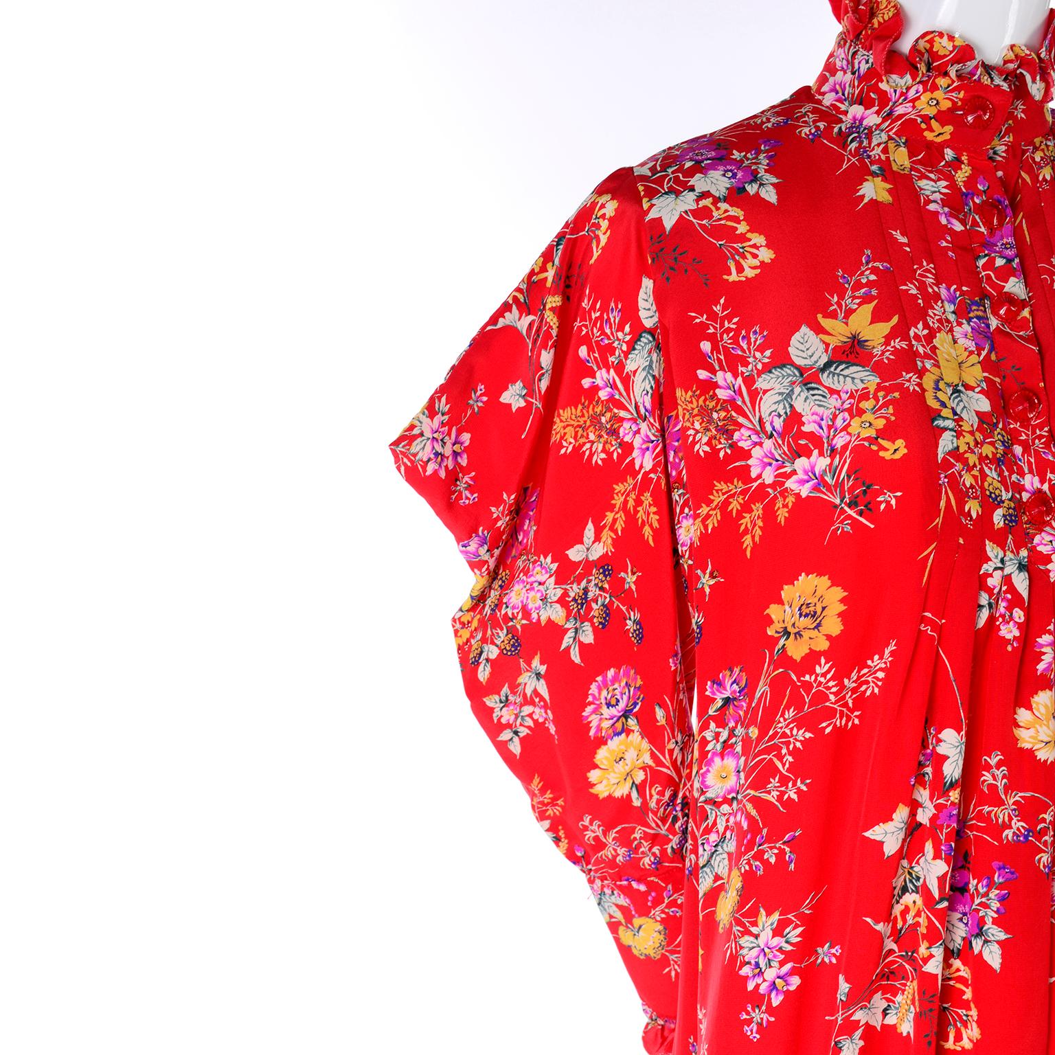 This is a beautiful and bright silk vintage dress with a high neck n a yellow, purple and green floral silk print designed by Emanuel Ungaro. It is a beautiful, flowing tent dress that has unique peaked avant garde sleeves! The long sleeves drape