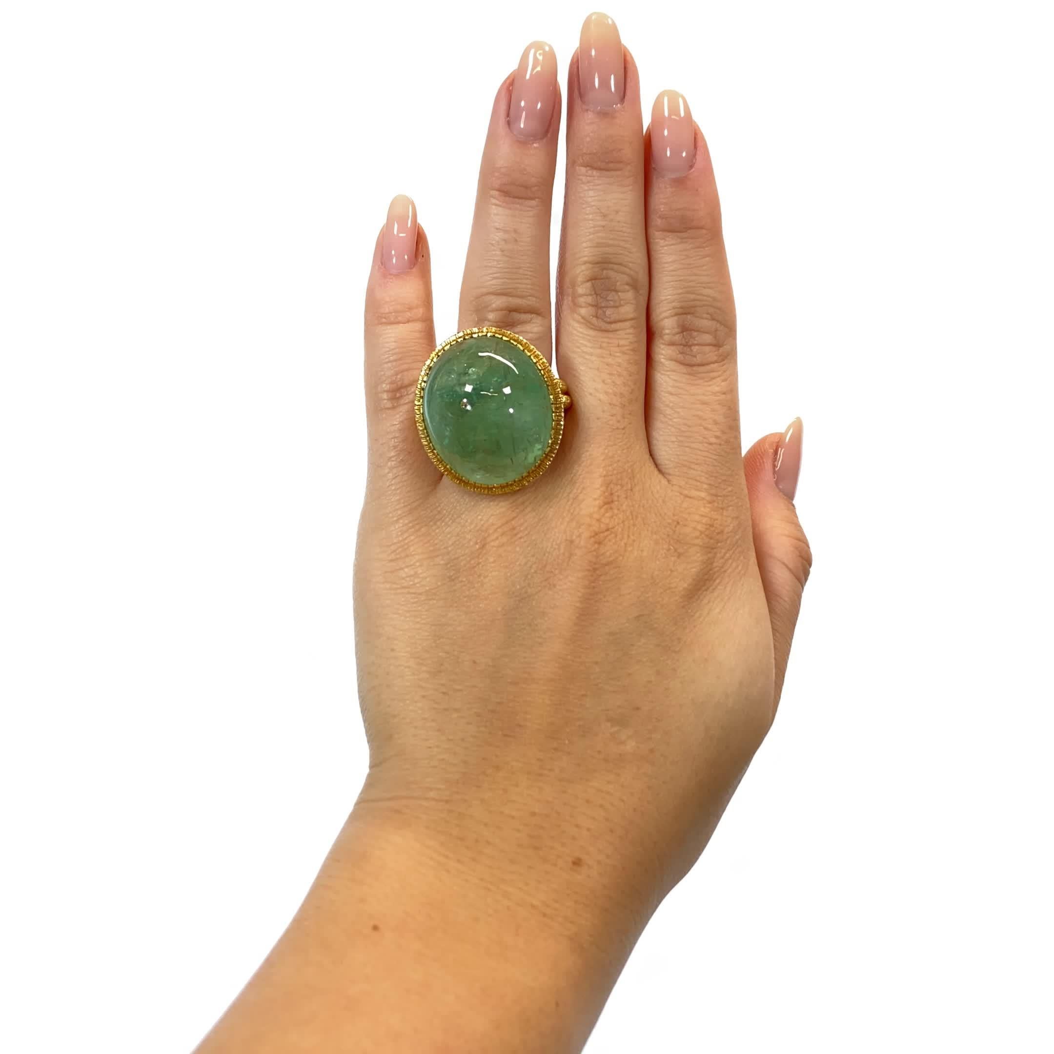 Vintage Emerald 18 Karat Gold Cocktail Ring. The ring features a cabochon cut emerald, approximately 56.00 carat. Circa 1980s. Size 5 and may be resized.

About The Piece: Feel yourself like a Greek Goddess, sipping wine under the olive tree with