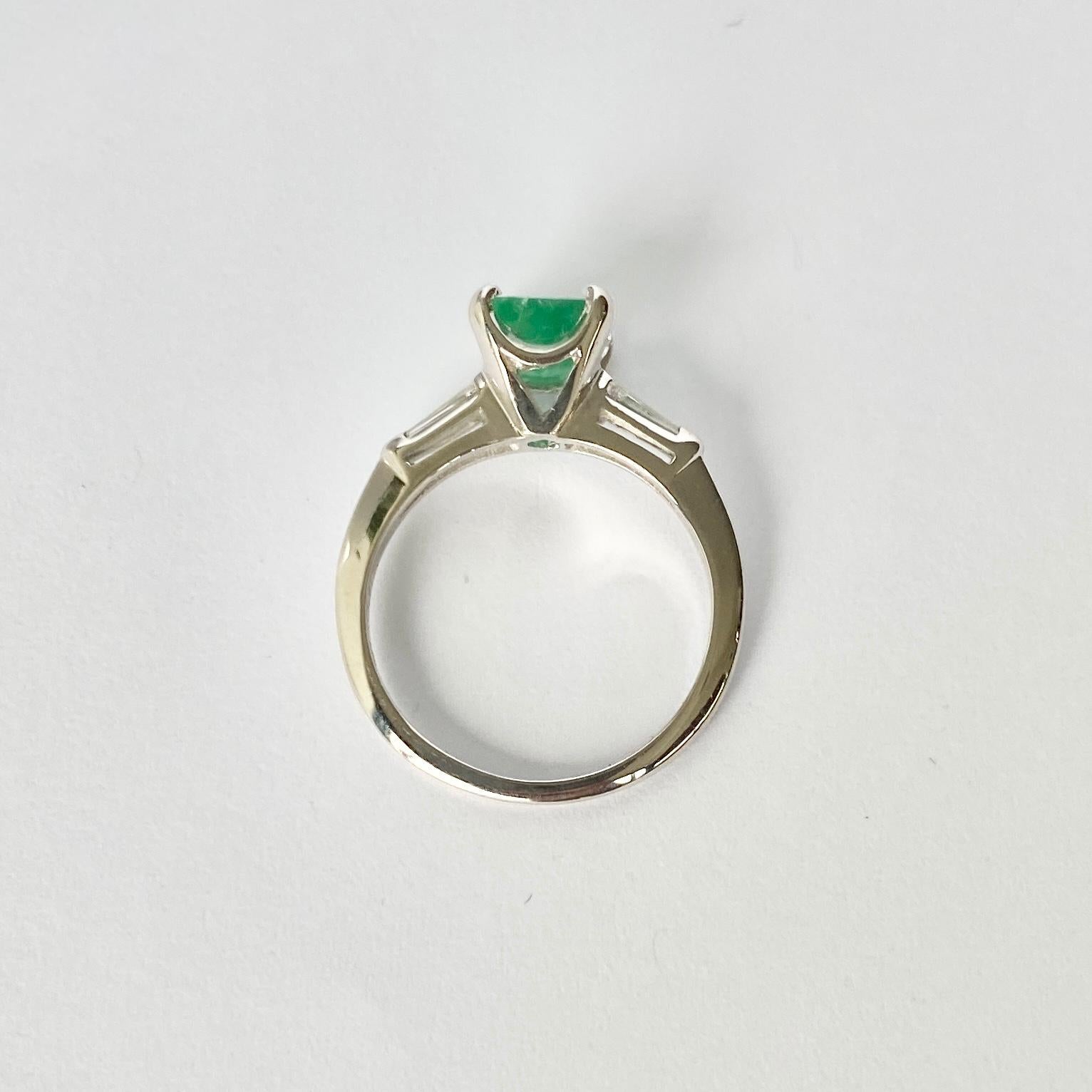 The Emerald in this ring measures 1ct and is a great colour. Either side sit a tapered baguette diamond on the shoulders. The ring is modelled out of 14ct white gold. 

Ring Size: K 1/2 or 5 1/2 
Height Off Finger: 8mm

Weight: 2.3g