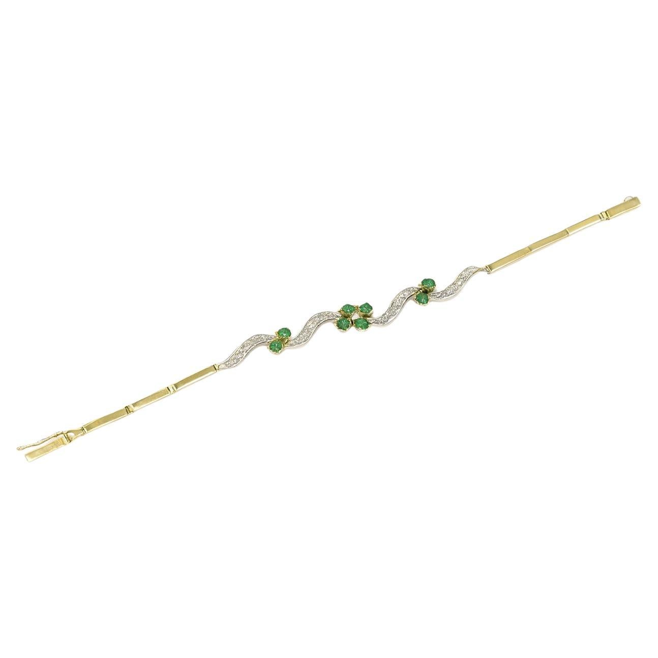 This vintage bracelet from the mid-century era combines vibrant color with refined craftsmanship. Designed in 14k two-tone gold and weighing 13 grams, it features clusters of bright green emeralds set between diamond-studded rippling links, creating