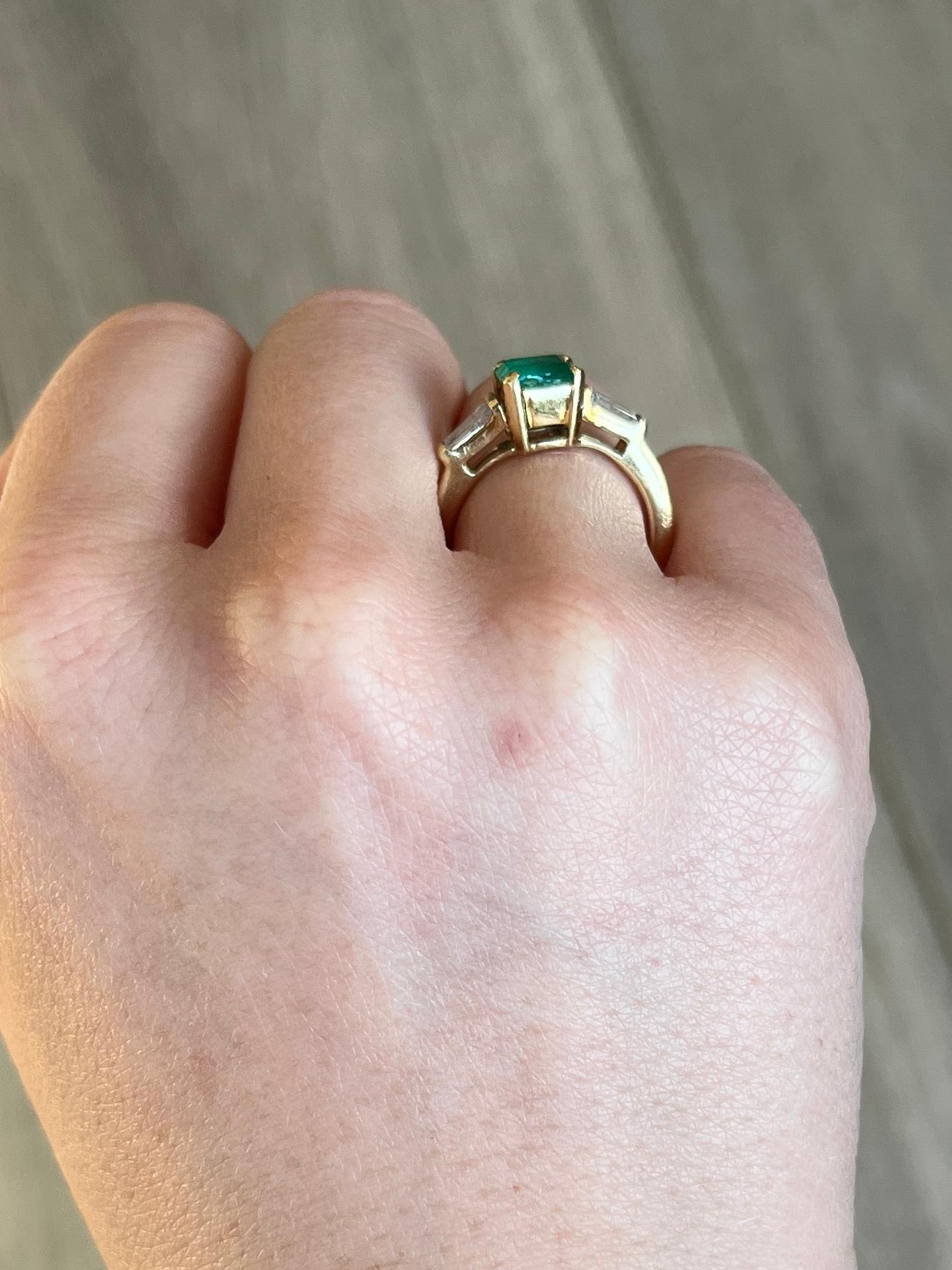 Der Smaragd in diesem Ring misst 60 Punkte und hat eine tolle Farbe. Auf beiden Seiten sitzt ein sich verjüngender Baguette-Diamant, die Diamanten insgesamt ist ca. 20pts. Der Ring ist aus 18 Karat Gold modelliert. 

Ringgröße: K 1/2 oder 5 1/2