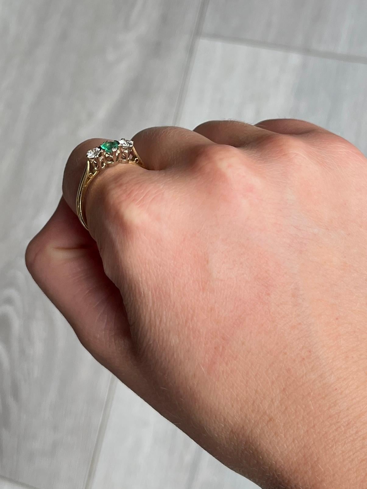 The central emerald is so bright and beautiful and measures 30pts. Sat either side it are two bright shimmering old European cut diamonds each measuring 20pts each. The ring is modelled in 18ct gold. Hallmarked Birmingham 1975. 

Ring Size: S 1/2 or