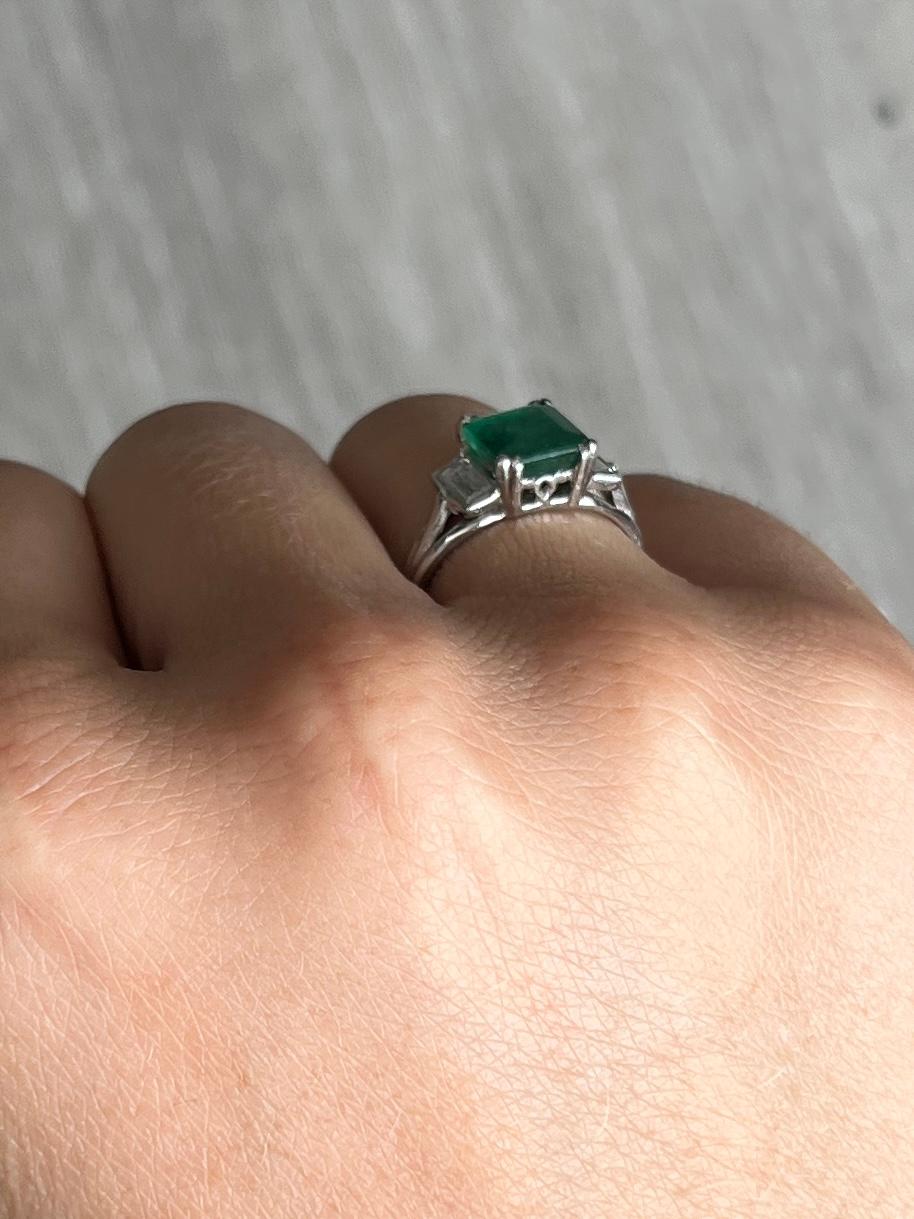Der Smaragd in diesem Ring misst 1.5ct und hat eine tolle Farbe. Auf jeder Seite sitzt ein Baguette-Diamant, die Diamanten insgesamt ist ca. 30pts. Der Ring ist aus 18 Karat Weißgold modelliert. 

Ringgröße: K oder 5 1/4
Höhe ohne Finger: 5,5