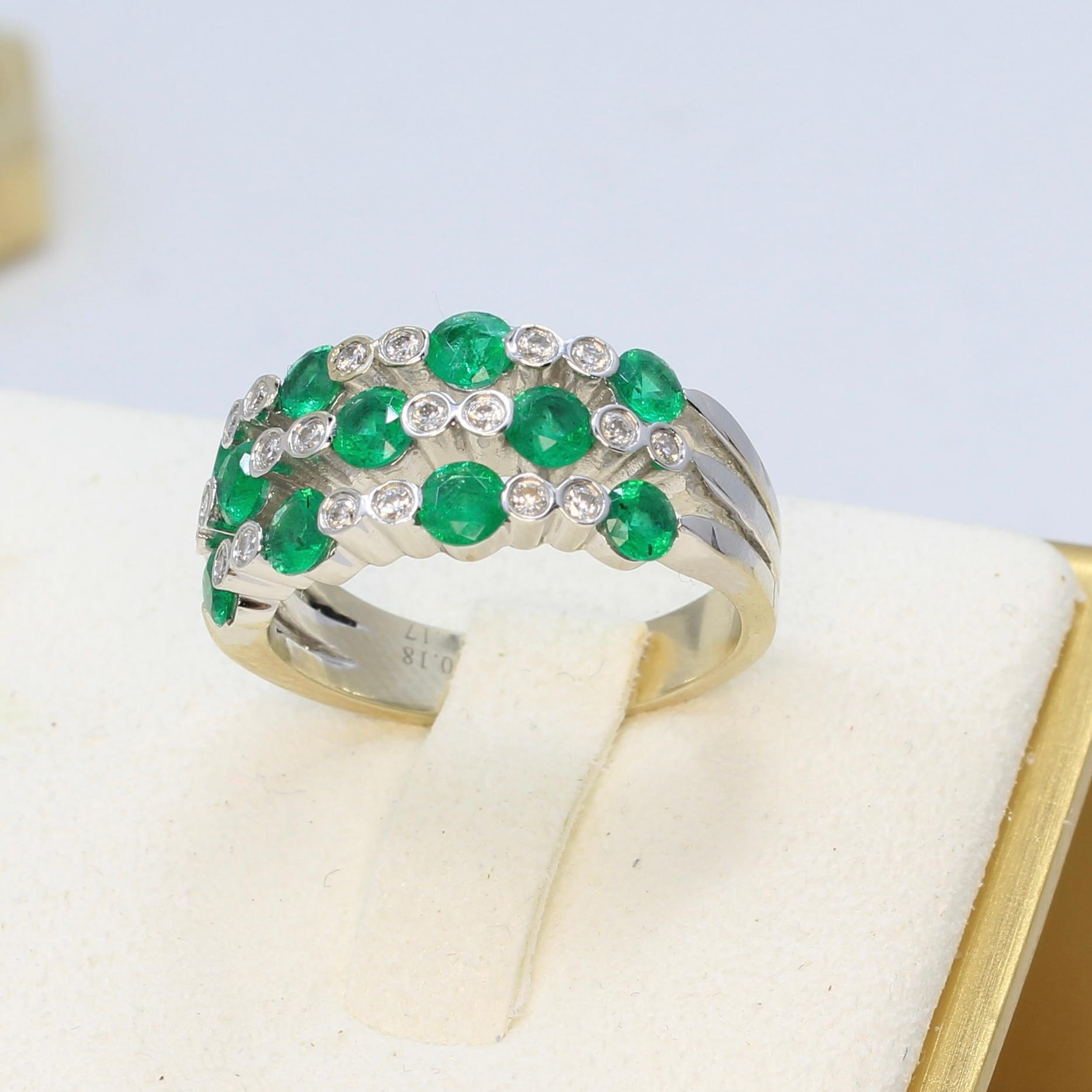 Ein wunderschöner Smaragd- und Diamantring mit intensiv grünen runden Smaragden, die von runden Diamanten in der Lünette akzentuiert werden. Dieser Ring hat drei Reihen von Smaragden und Diamanten, die den Finger gut bedecken. Dieser exquisite Ring