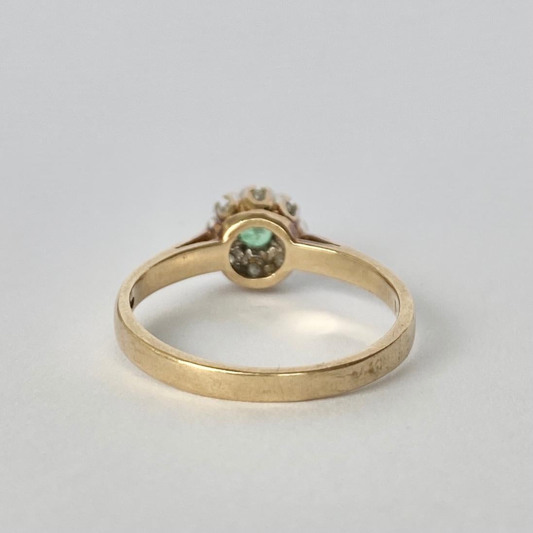 The wonderful bright emerald at the centre of this cluster measures approximately 30pts and is surrounded by a glittering halo of diamonds totalling 10pts. Modelled in 9carat gold and diamonds set in platinum. Fully hallmarked Birmingham 1987.

Ring