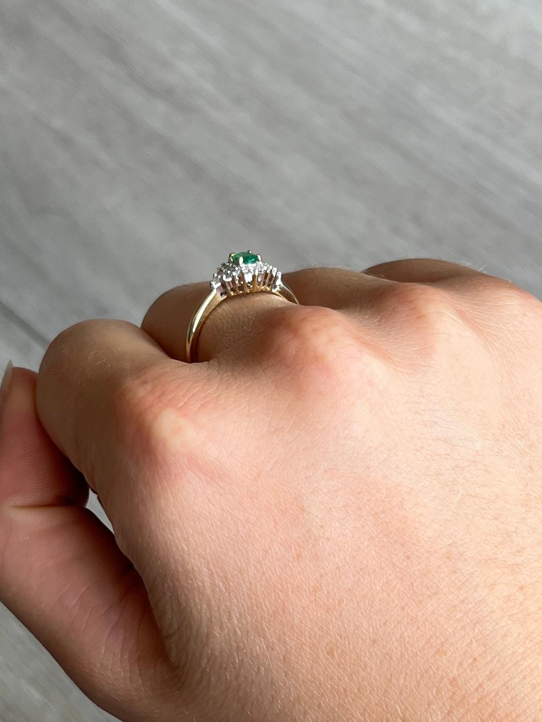 This stunning cluster boasts a 35pt emerald at the centre of it. Surrounding the beautiful green stone are diamonds totalling 28pts. All modelled in 9carat gold and stones set in platinum. 

Ring Size: N 1/2 or 7
Cluster Dimensions: 11x7mm

Weight: