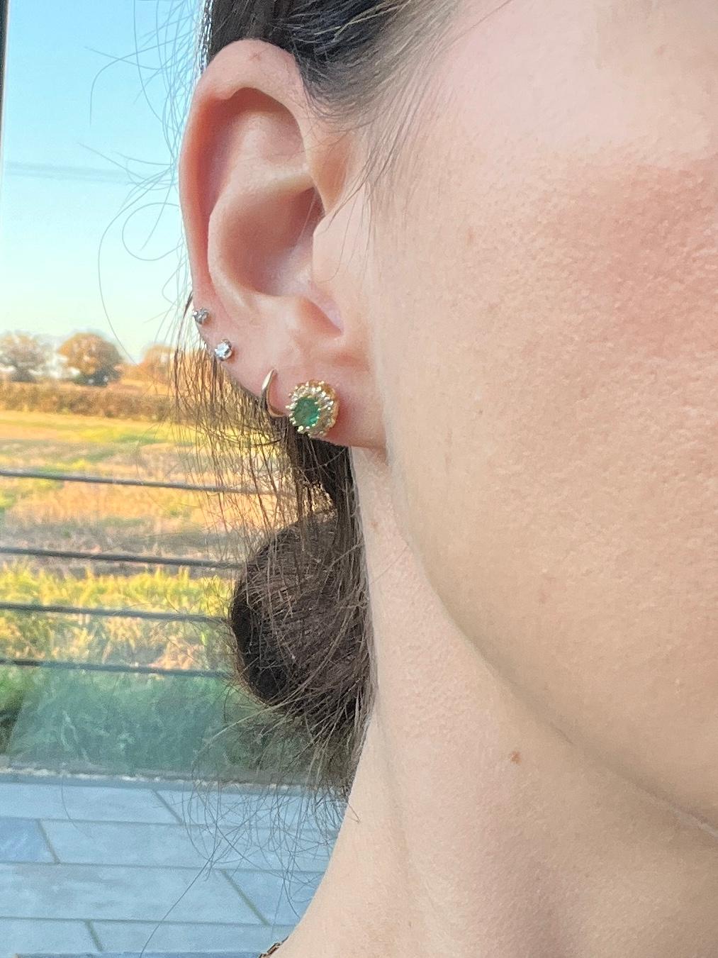Gli smeraldi al centro di questi bellissimi e classici orecchini a grappolo misurano 40pt ciascuno e sono di colore brillante. L'alone di diamanti che circonda questa pietra misura un totale di 11pts per orecchino. 

Dimensioni: 9x7mm

Peso: 2,4 g
