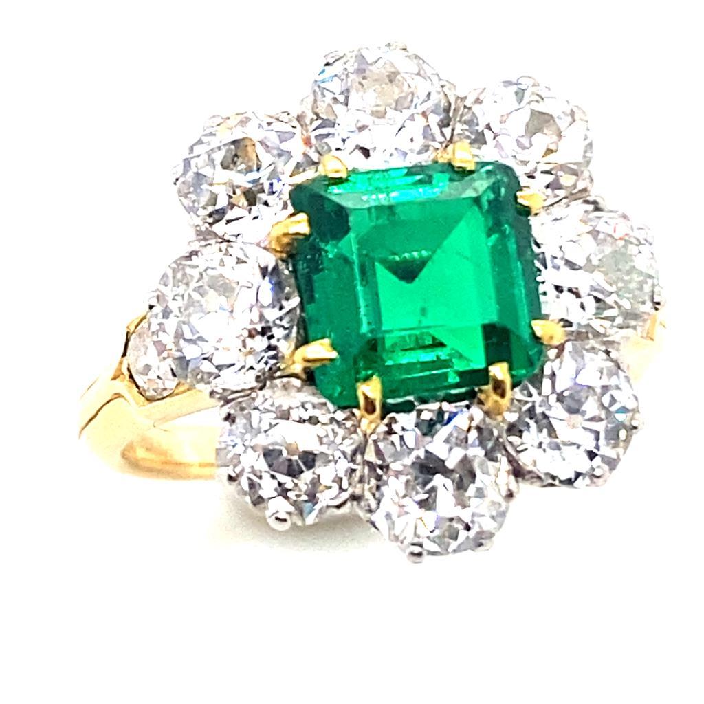 A vintage emerald and diamond cluster ring in 18 karat yellow gold, circa 1915.

This exceptional ring is set to its centre with a square cut emerald of 1.40cts approximately with an accompanying certificate from The Gemmological Laboratory of Bond
