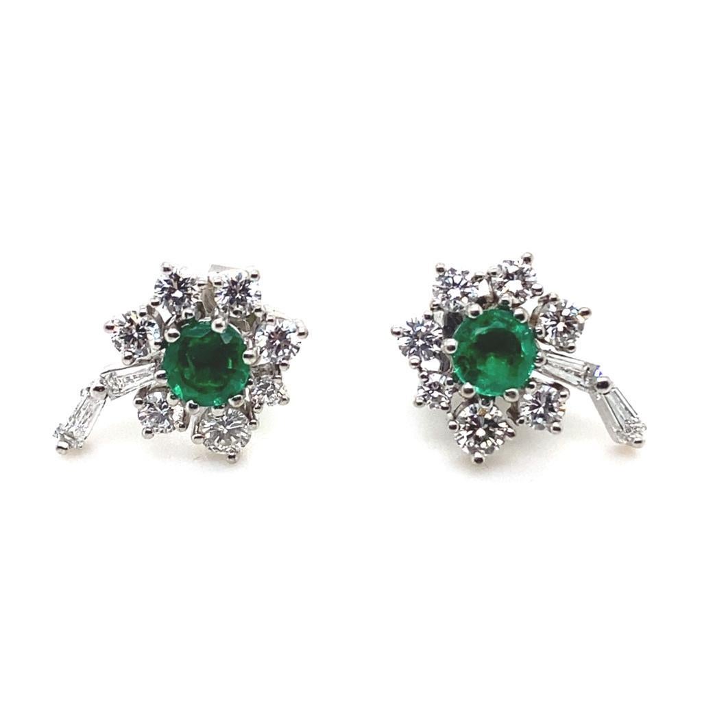 A pair of vintage emerald and diamond cluster flower earrings in 18 karat white gold, circa 1960

Each elegant flower earring is set with a round cut emerald of a fine deep green colour for a total weight of 0.35 carats approximately, within a