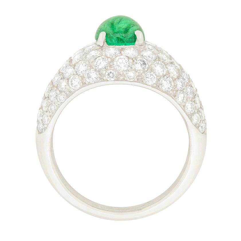 This is an interesting and unique dress ring, with true sparkle. The centre Emerald is a cabochon cut and is a wonderful sea green. It is claw set with platinum, and is surrounded by grain set round brilliants.

The emerald weighs 1.60 carat, whilst