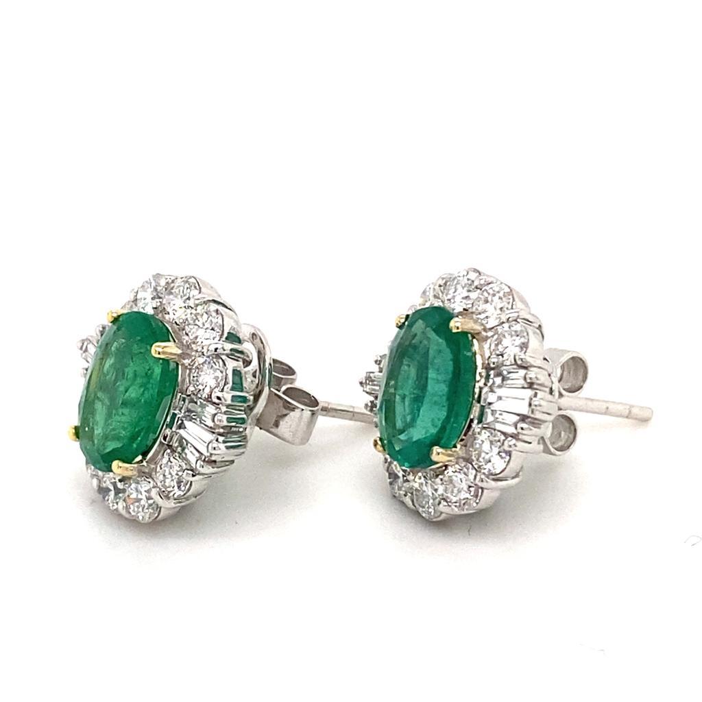 A pair of vintage emerald and diamond platinum cluster earrings, circa 1980.

These elegant cluster earrings are set with oval cut emeralds of a desirable deep green colour for a total weight of 2.58 carats approximately, within a beautifully