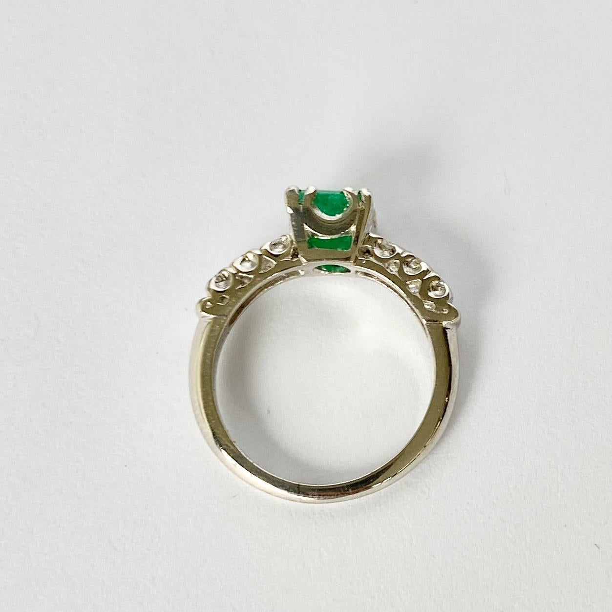 The Emerald in this ring measures 60pts and is a great colour. Either side sit a trio of diamonds totalling 10pts per shoulder. The ring is modelled out of Platinum. 

Ring Size: H or 3 3/4
Height Off Finger: 5.5mm

Weight: 4g