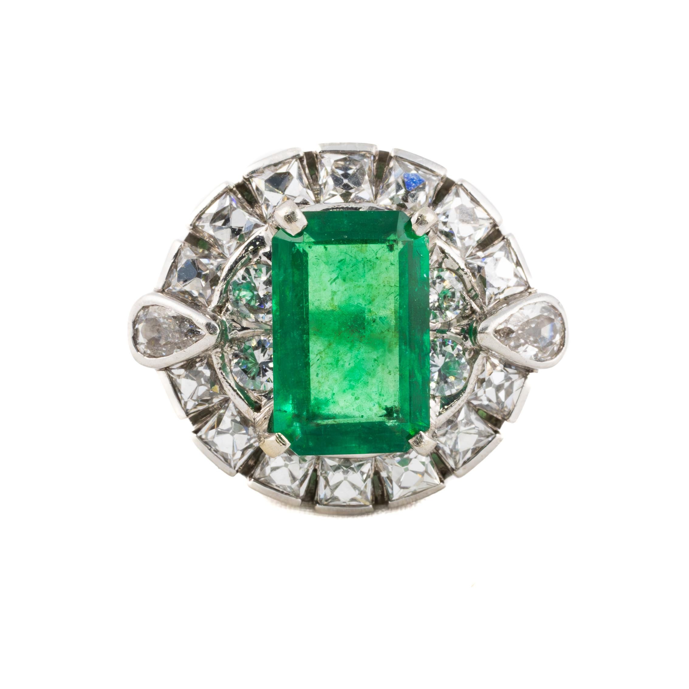 Anillo de cóctel vintage de oro blanco con esmeralda y diamantes

Este impresionante anillo exhibe una llamativa esmeralda de 3,42 quilates en su centro, que irradia un exuberante tono verde que cautiva la mirada. La esmeralda está elegantemente