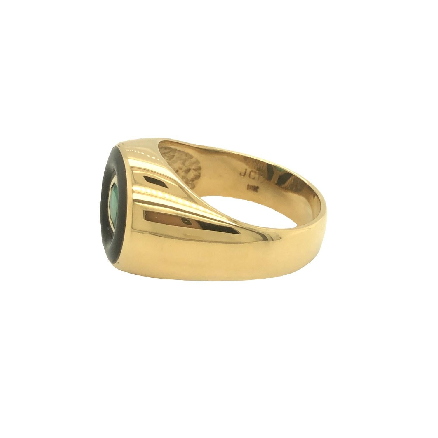 Bold and stunning men's ring highlights a deep vivid green emerald weighing approximately 0.80 carat. The emerald is framed in an exquisite hand cut onyx that evokes a striking contrast of color. The ring was handcrafted in high polished 18K yellow