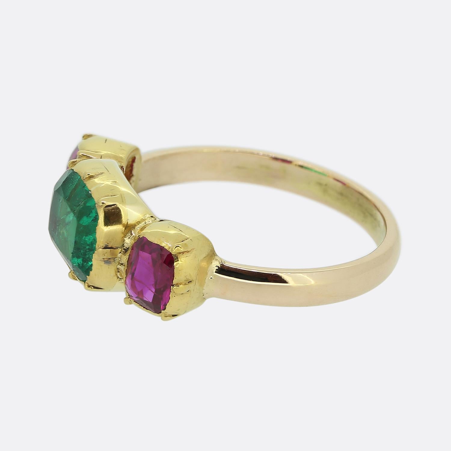 Here we have a remarkable emerald and ruby three-stone ring. The head of this vintage piece has been crafted from 22ct yellow gold and features a trio of precious gemstones. An oval shaped Colombian emerald possessing an astoundingly vivid electric