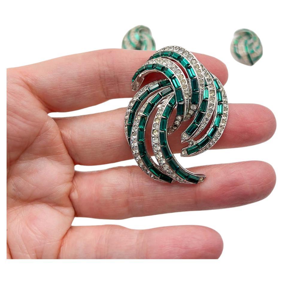 An exquisite Vintage Emerald Brooch and Earring Set with the look of Boucher however unsigned. Crafted and designed to perfection this suite is the ultimate style statement. The green and white hand set crystals bringing an emerald and diamond vibe