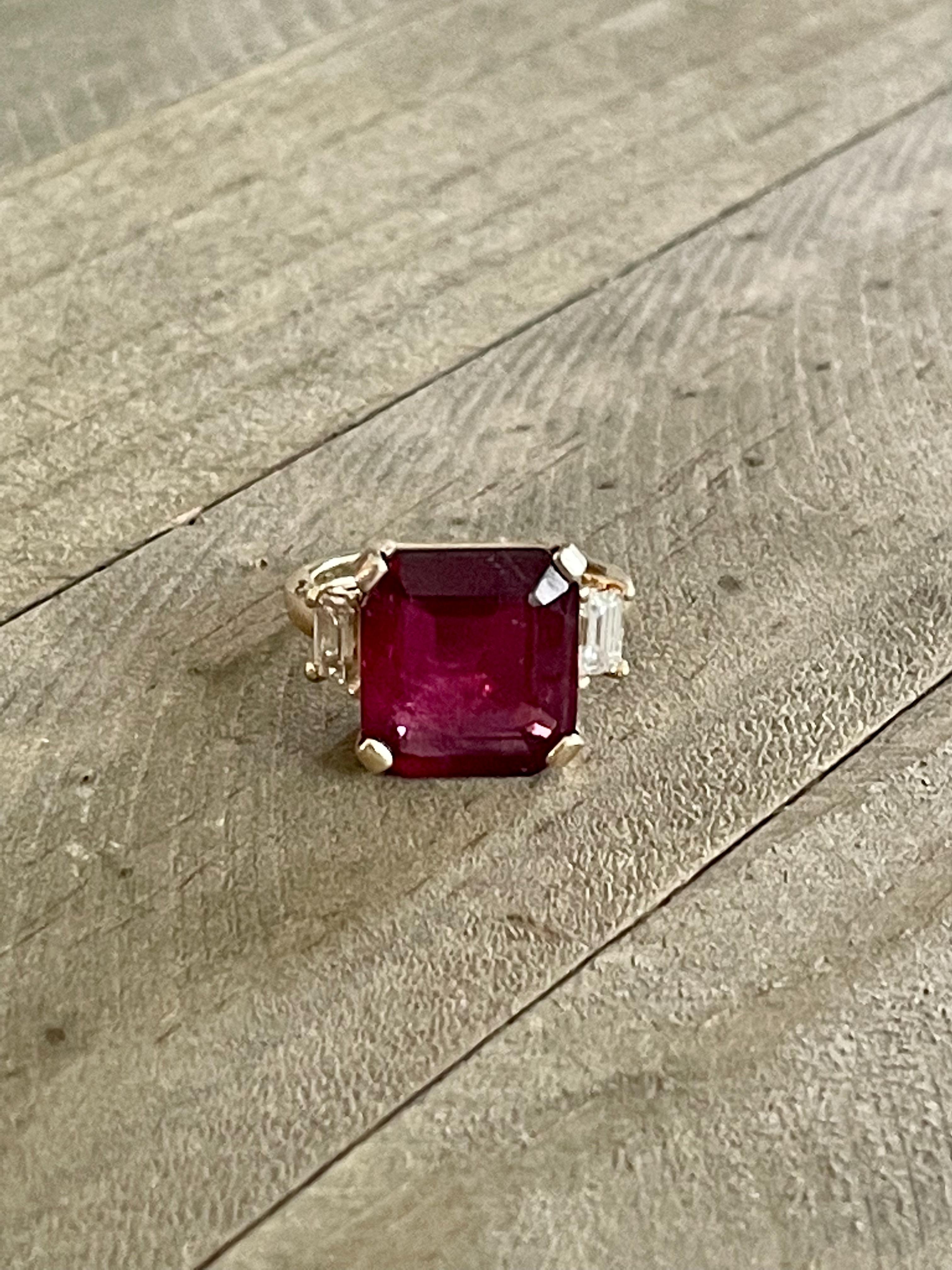 This ring is fabulous!!!  It features a large 13 x 12mm emerald cut Rubellite Tourmaline center stone. On each side of the Tourmaline, there is a straight baguette side Diamond.  Approximate weight of Diamonds is .50cts with grades of