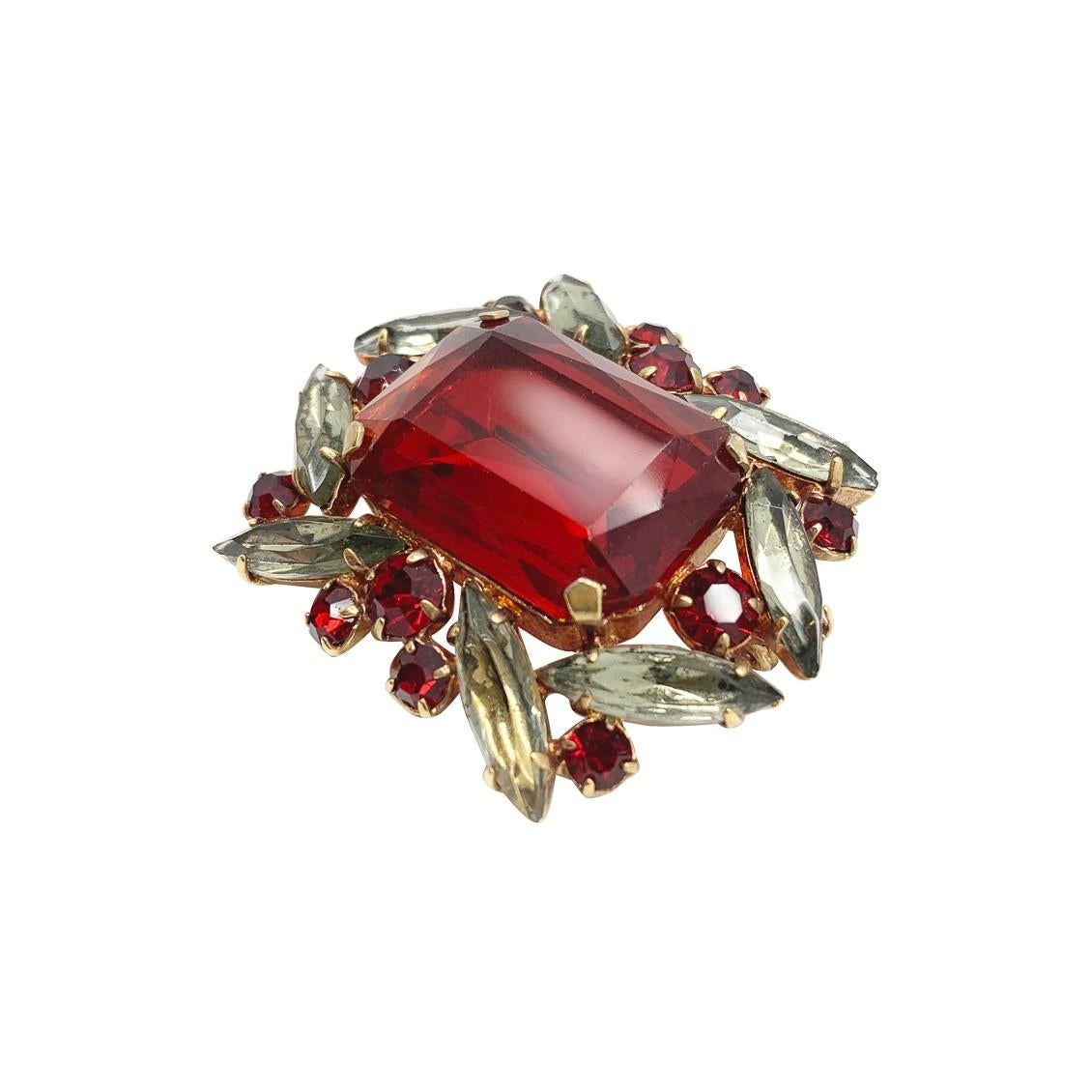 A vintage red crystal brooch from the mid century, presenting a rare and beautiful combination of deep red fancy cut crystals accented with grey marquise stones. Totally alluring and beautifully made. A perfect piece to adorn yourself with and sip