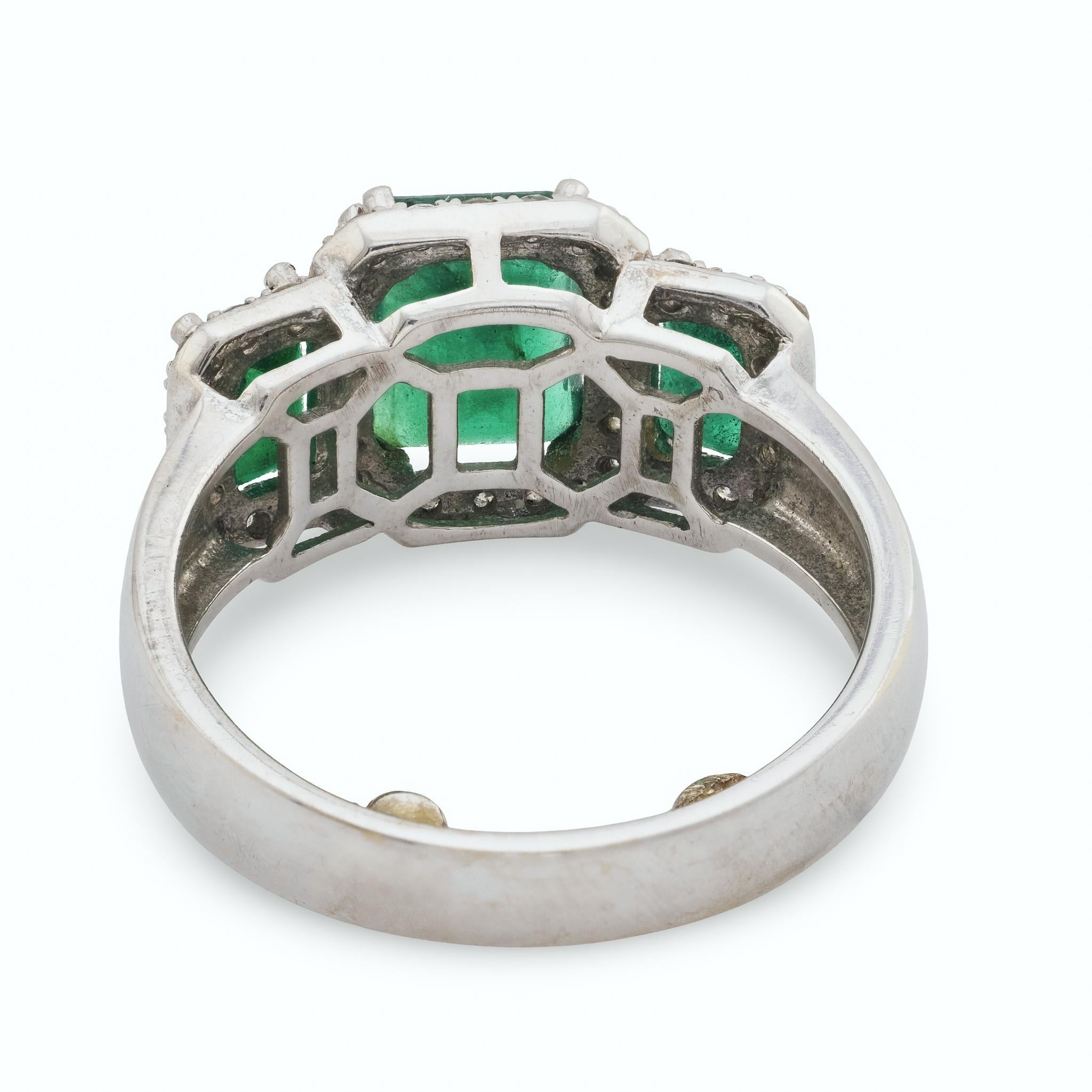 Taglio smeraldo Anello vintage con smeraldo e diamante in oro bianco 14 carati con tre pietre in vendita