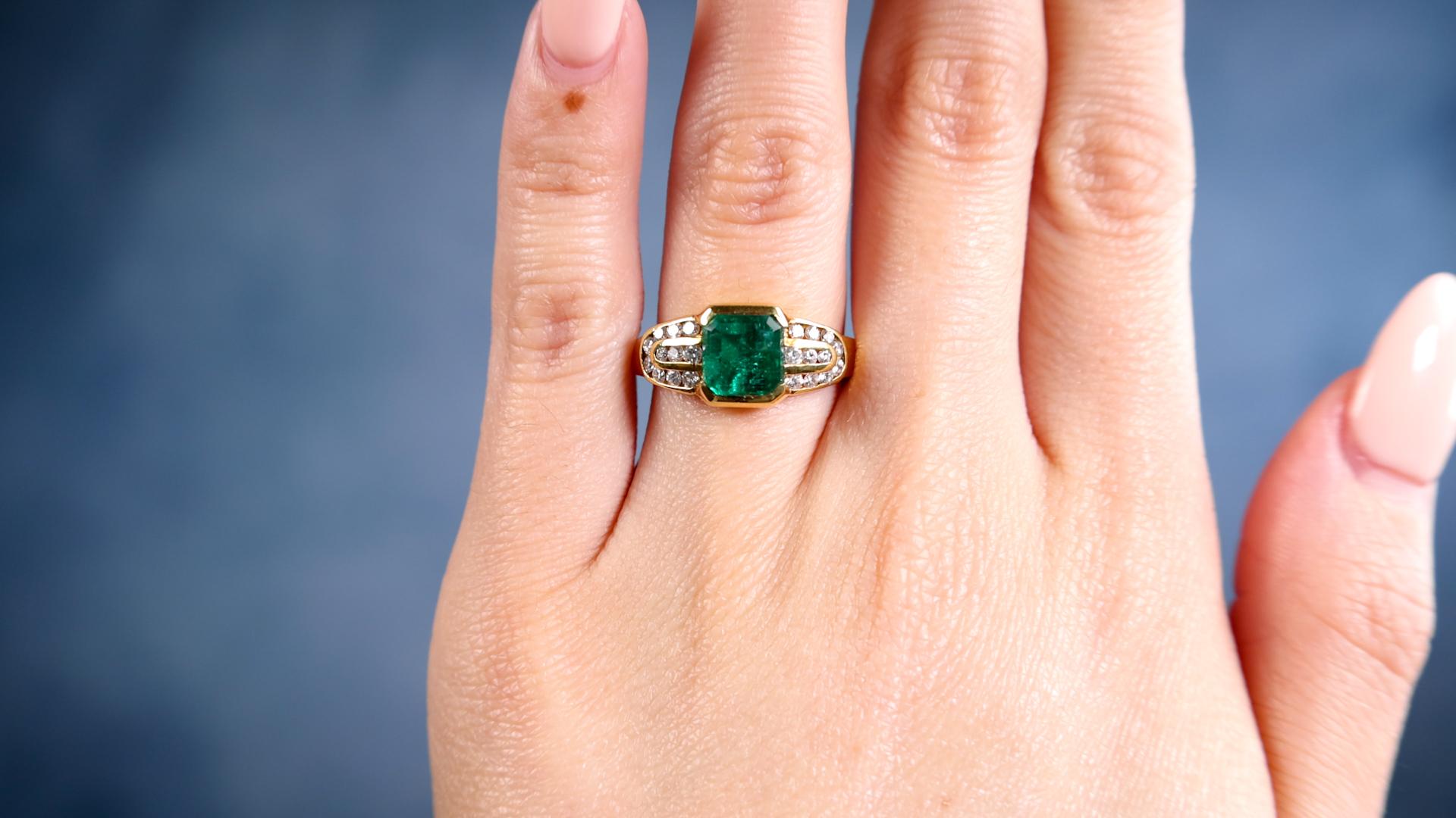 One Vintage Emerald Diamond 18k Yellow Gold Ring. Featuring one octagonal step cut emerald weighing approximately 1.45 carat. Accented by 22 round brilliant cut diamonds with a total weight of approximately 0.30 carat, graded F-G color, VS clarity.