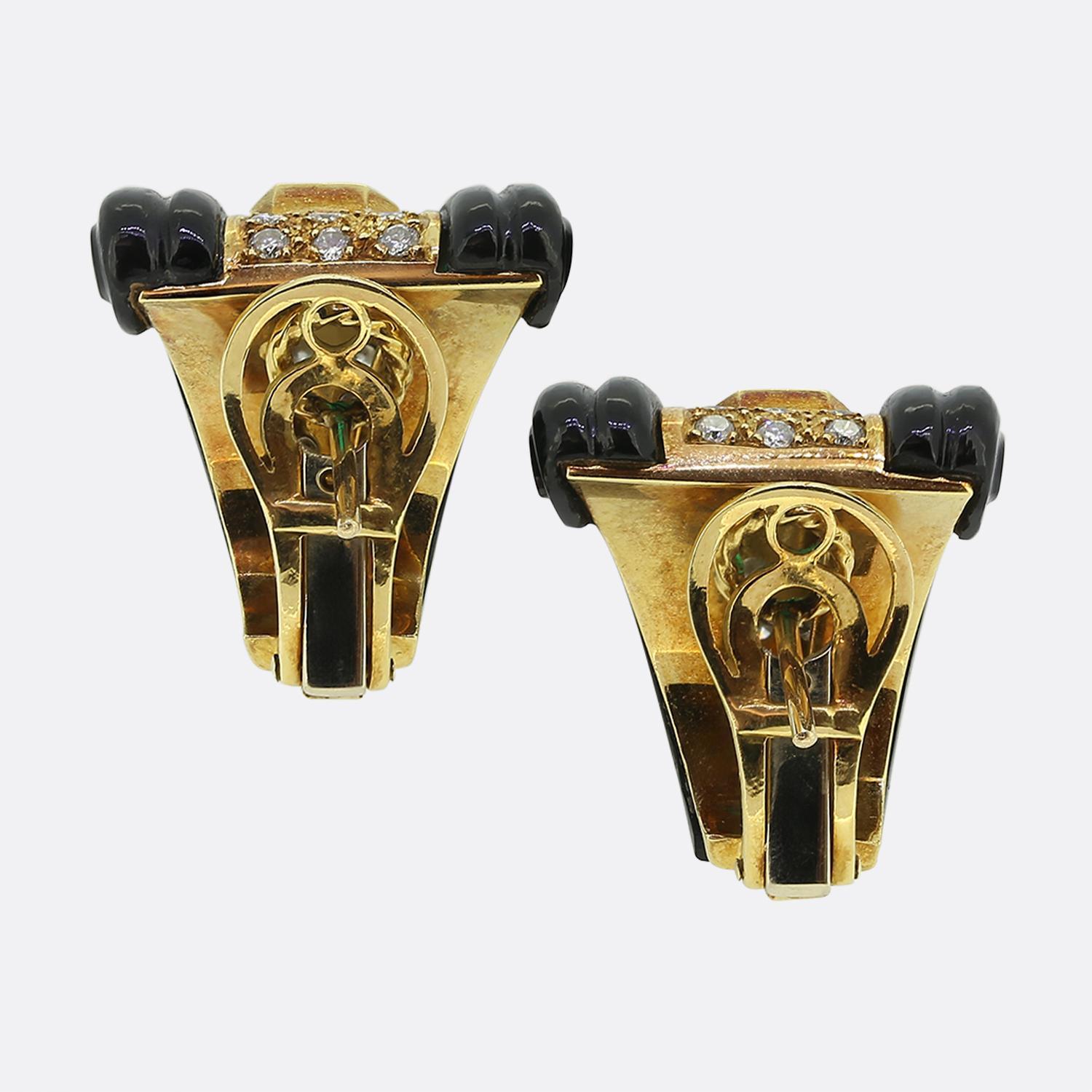 Here we have a wonderful pair of vintage earrings crafted in 18ct yellow gold. The focal point of each earring is a rich green emerald that sits at the centre whilst being flanked by scrolled onyx shoulders and diamonds above and below. The mix of