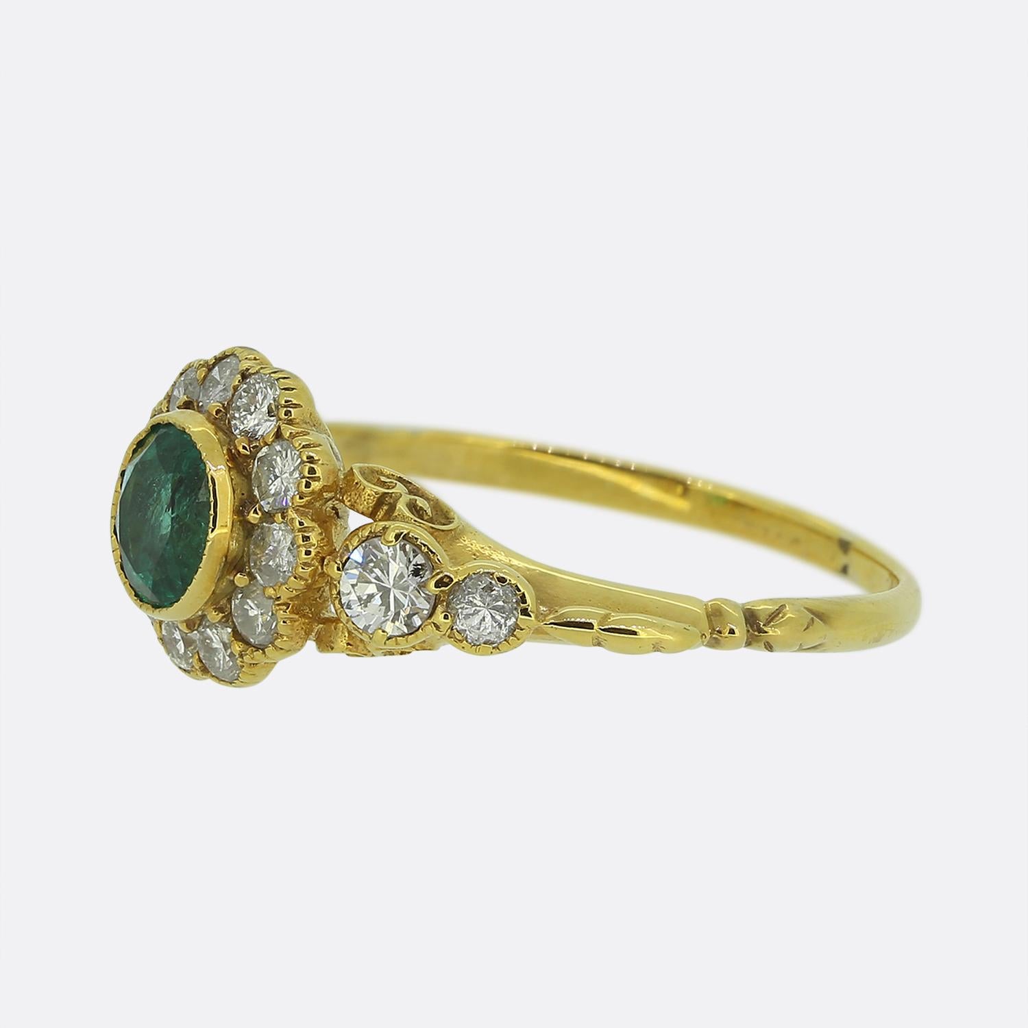 This is a wonderful emerald and diamond cluster ring crafted in 18ct yellow gold. The central emerald is a rich green hue and the surrounding diamonds are a bright white colour. 

Condition: Used (Very Good)
Weight: 2.4 grams
Ring Size: N 1/2