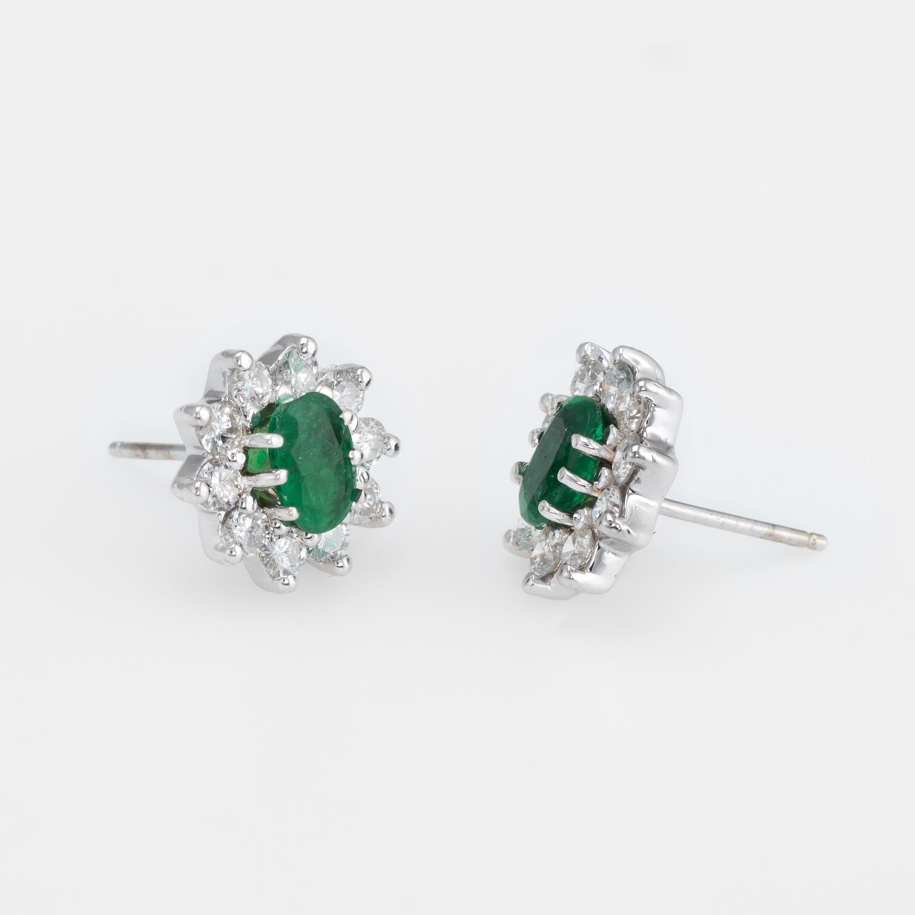 Elegant pair of estate emerald & diamond oval stud earrings, crafted in 14k white gold. 

Oval faceted emeralds measure 6mm x 5mm (estimated at 0.50 carats each - 1 carat total estimated weight). The 20 round brilliant cut diamonds (10 per earring)